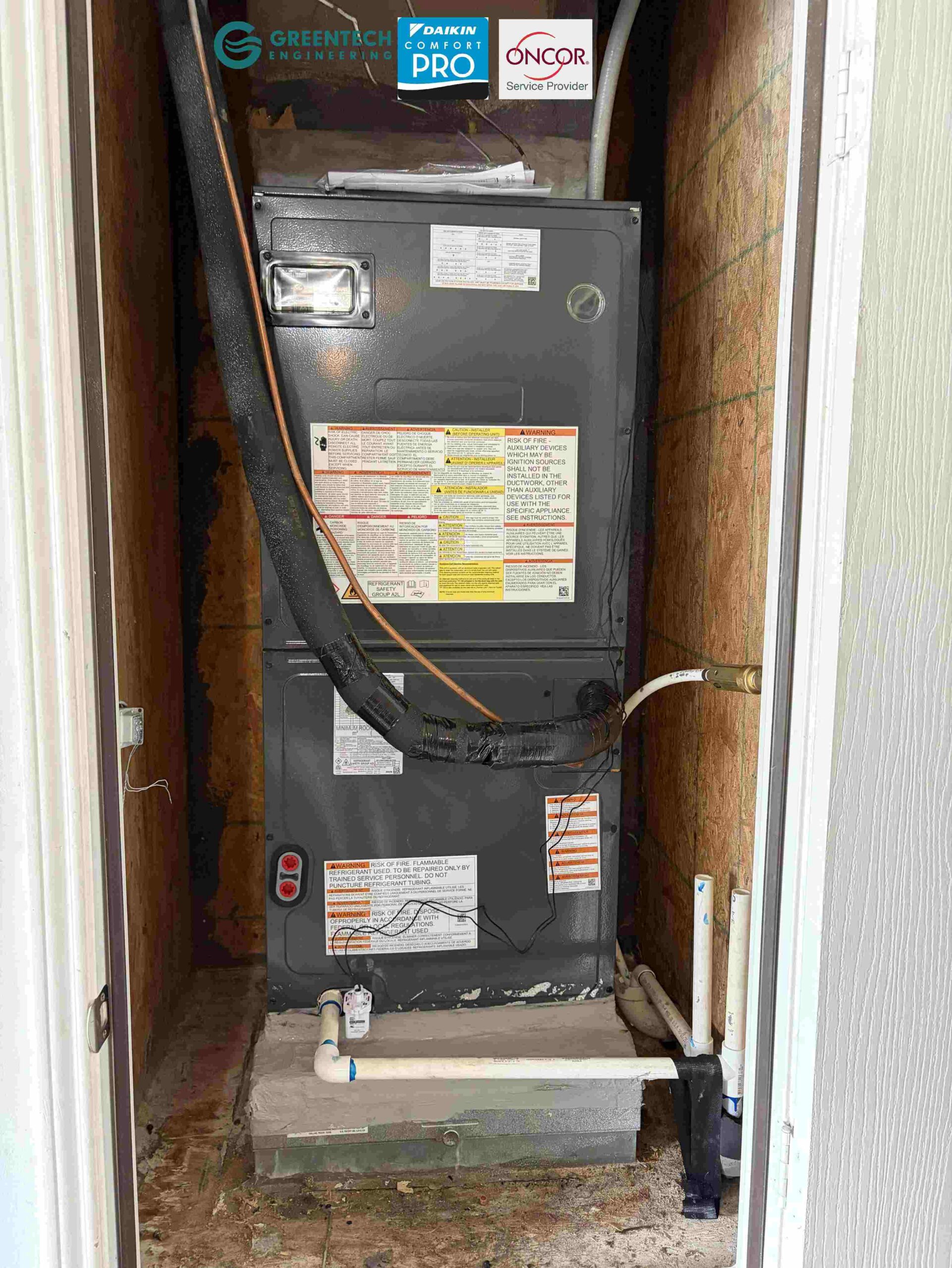 A brand new Goodman up-flow electrical air handler installed cleanly in a residential utility closet with new PVC drain lines.