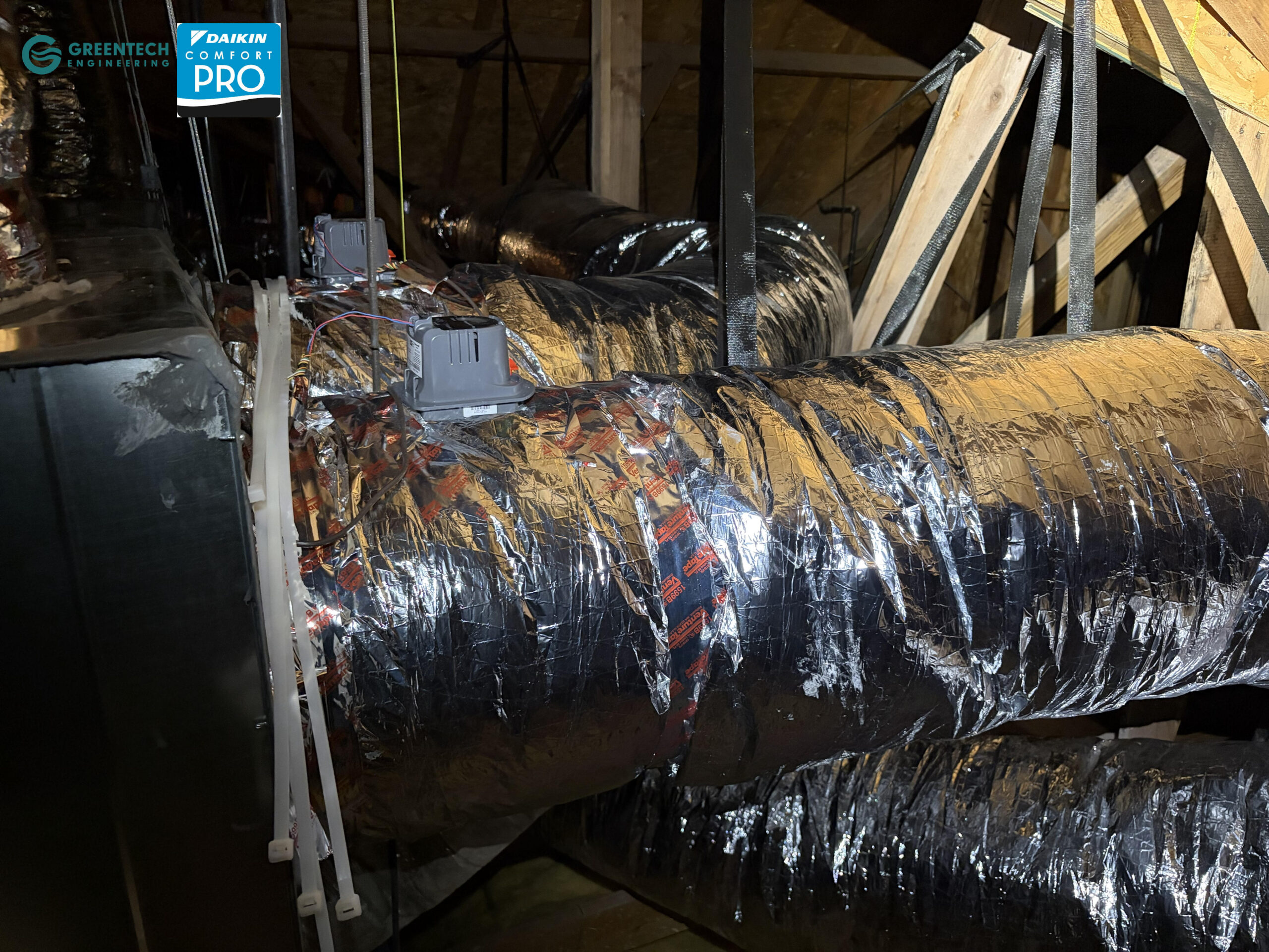 Newly installed commercial HVAC motorized zone dampers mounted on heavily insulated rigid ductwork in a Dallas 75248 ceiling space.