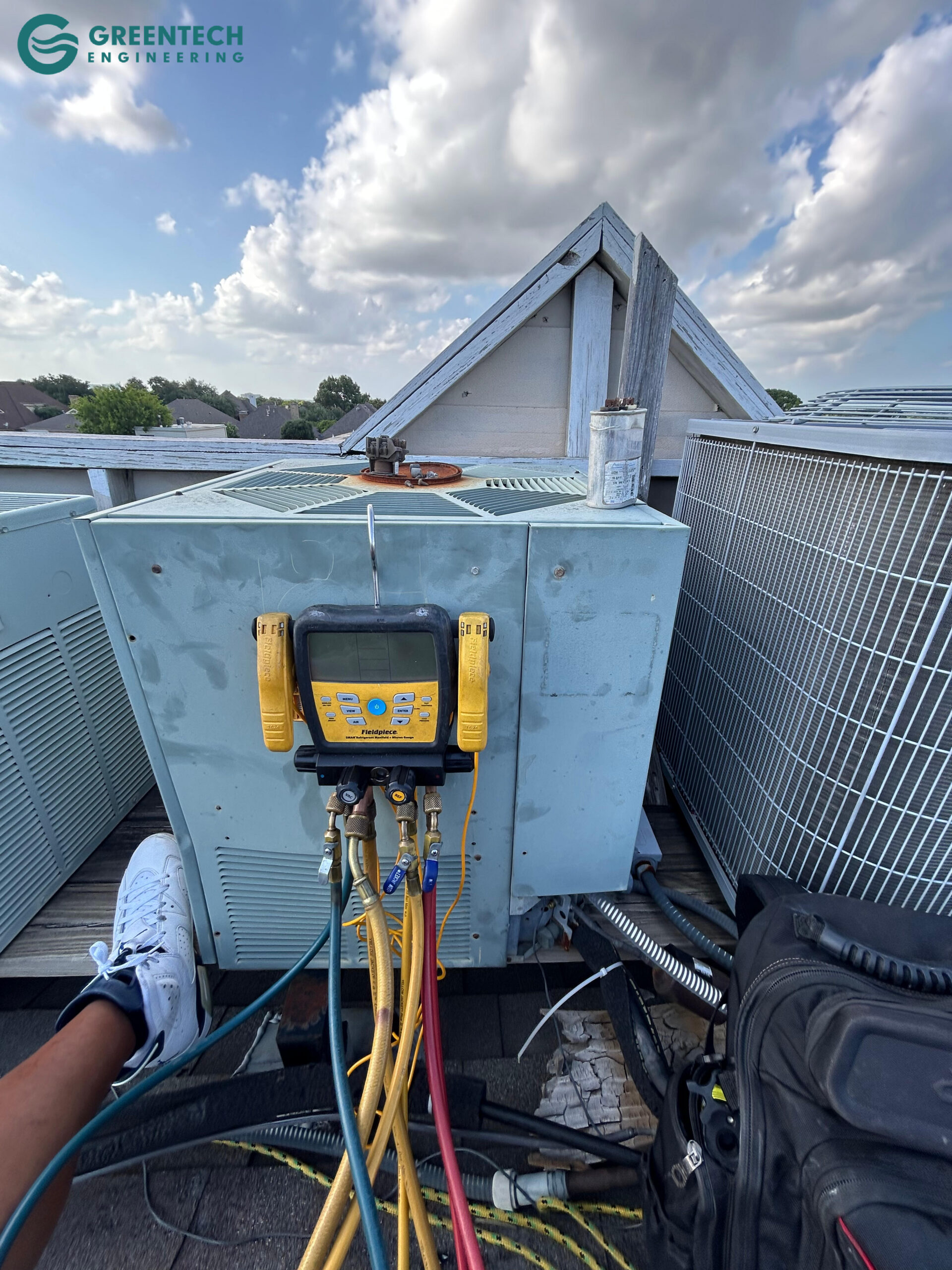 An aging, low-efficiency air conditioning condenser sitting on a weathered wooden rooftop platform in a Forney multi-family apartment complex.