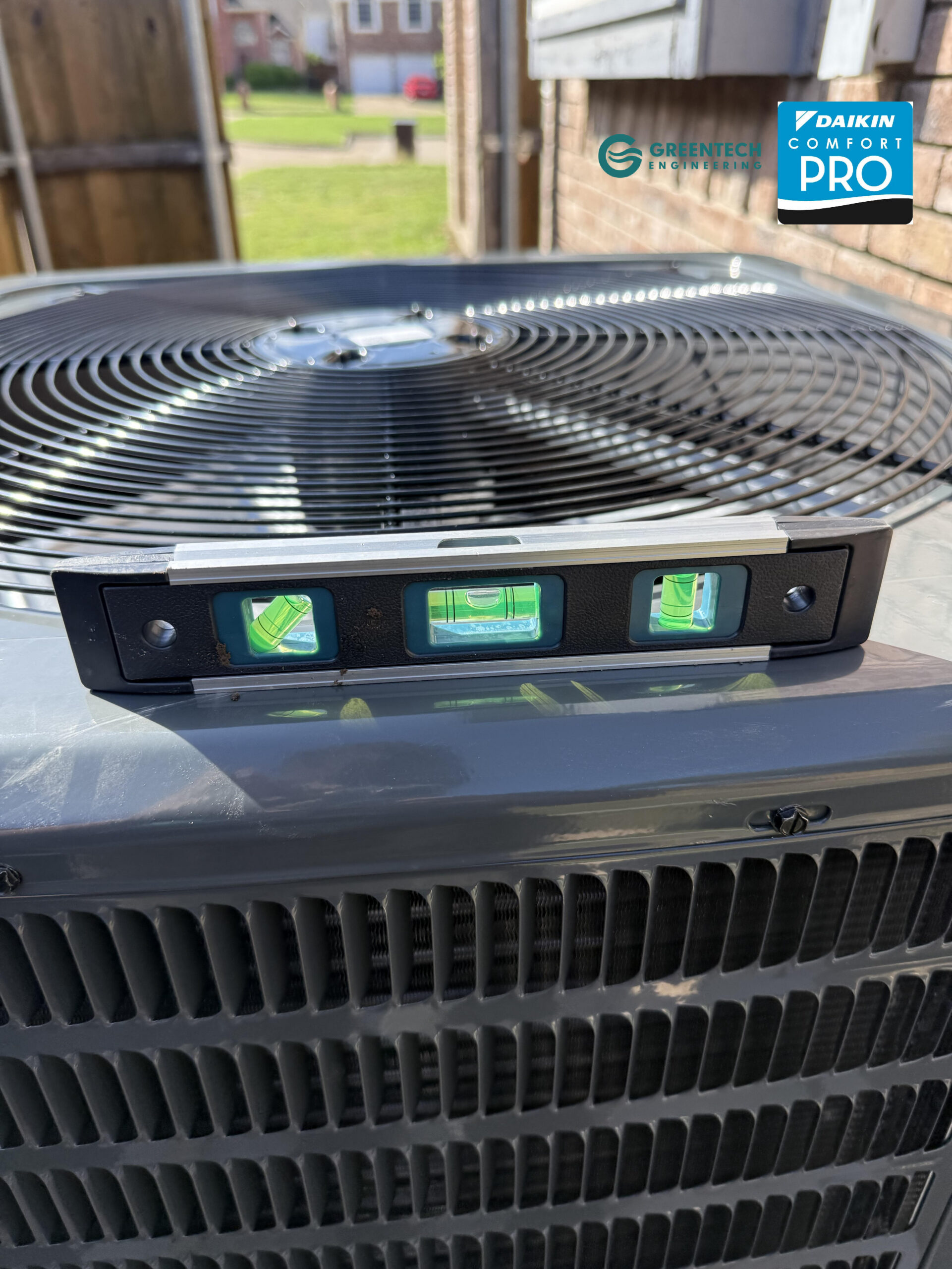 Greentech HVAC technician perfectly leveling a new Goodman heat pump condenser in Fort Worth.
