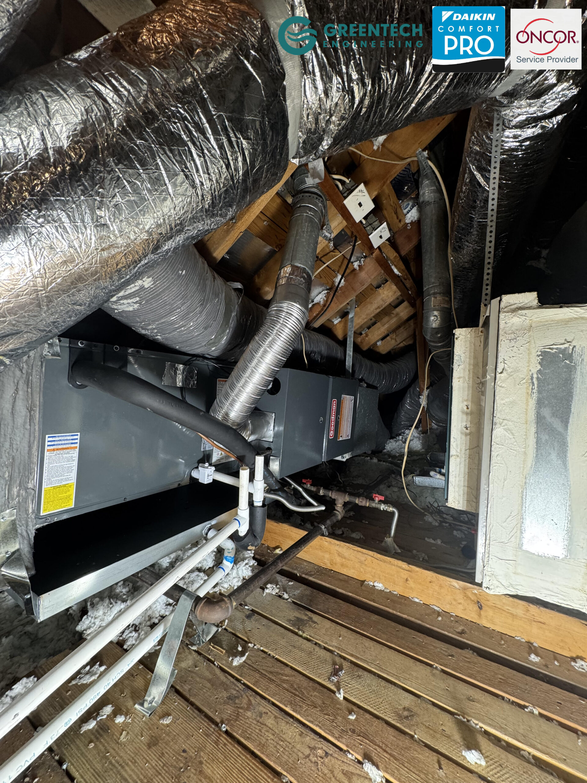 A newly installed Goodman horizontal gas furnace and cased evaporator coil in a Grand Prairie, TX attic, featuring sealed ductwork and clear drain lines.