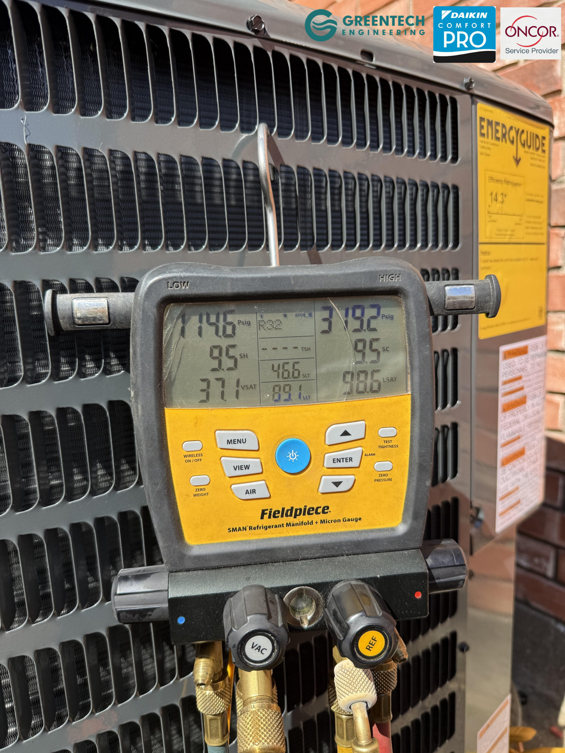 Greentech Engineering technician using a Fieldpiece digital manifold gauge to pull a sub-500 micron vacuum on a new Goodman AC installation in Grand Prairie, TX.