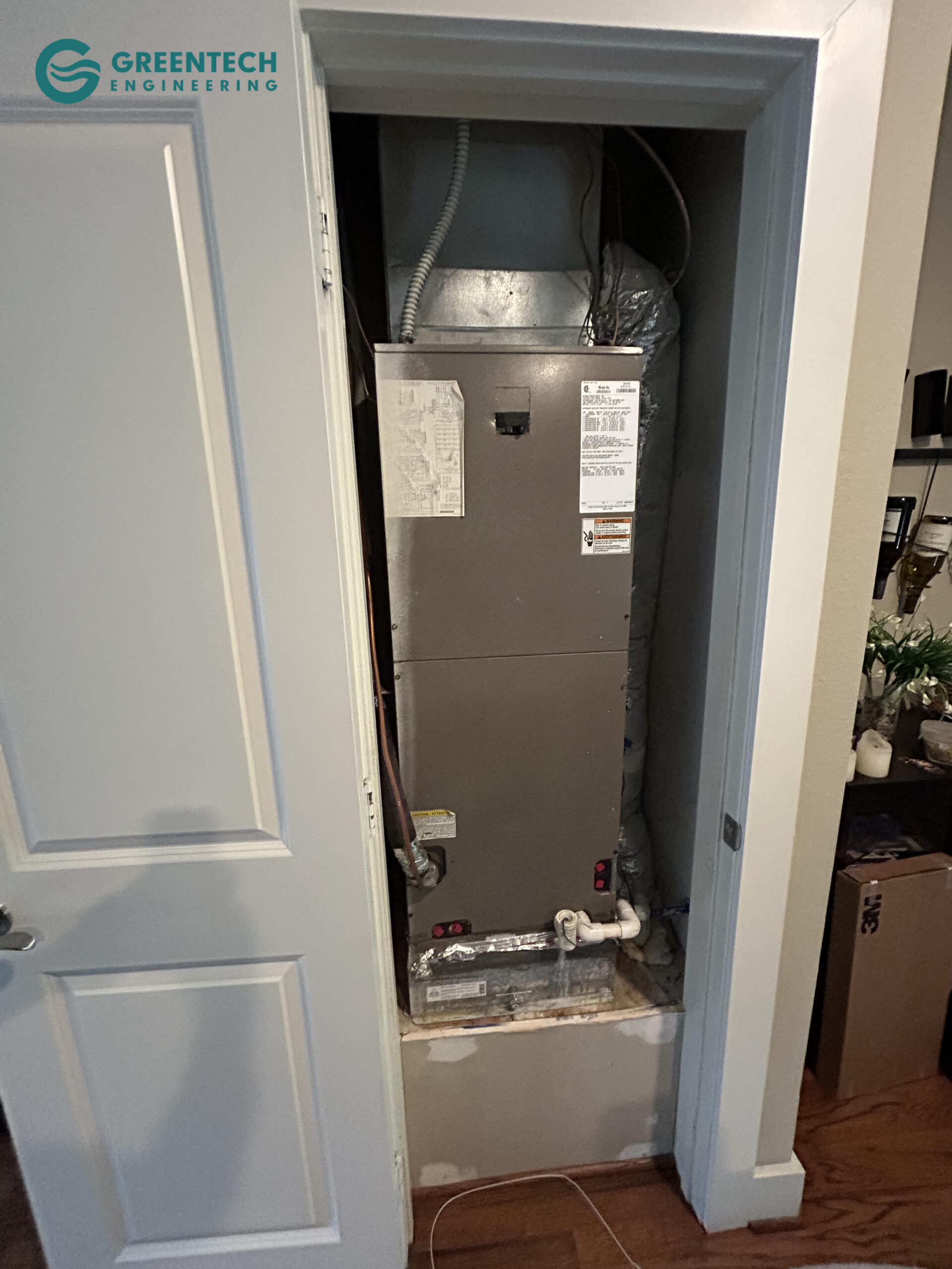 An older, inefficient indoor HVAC air handler and furnace unit crammed into a tight utility closet in a Far North Dallas home.