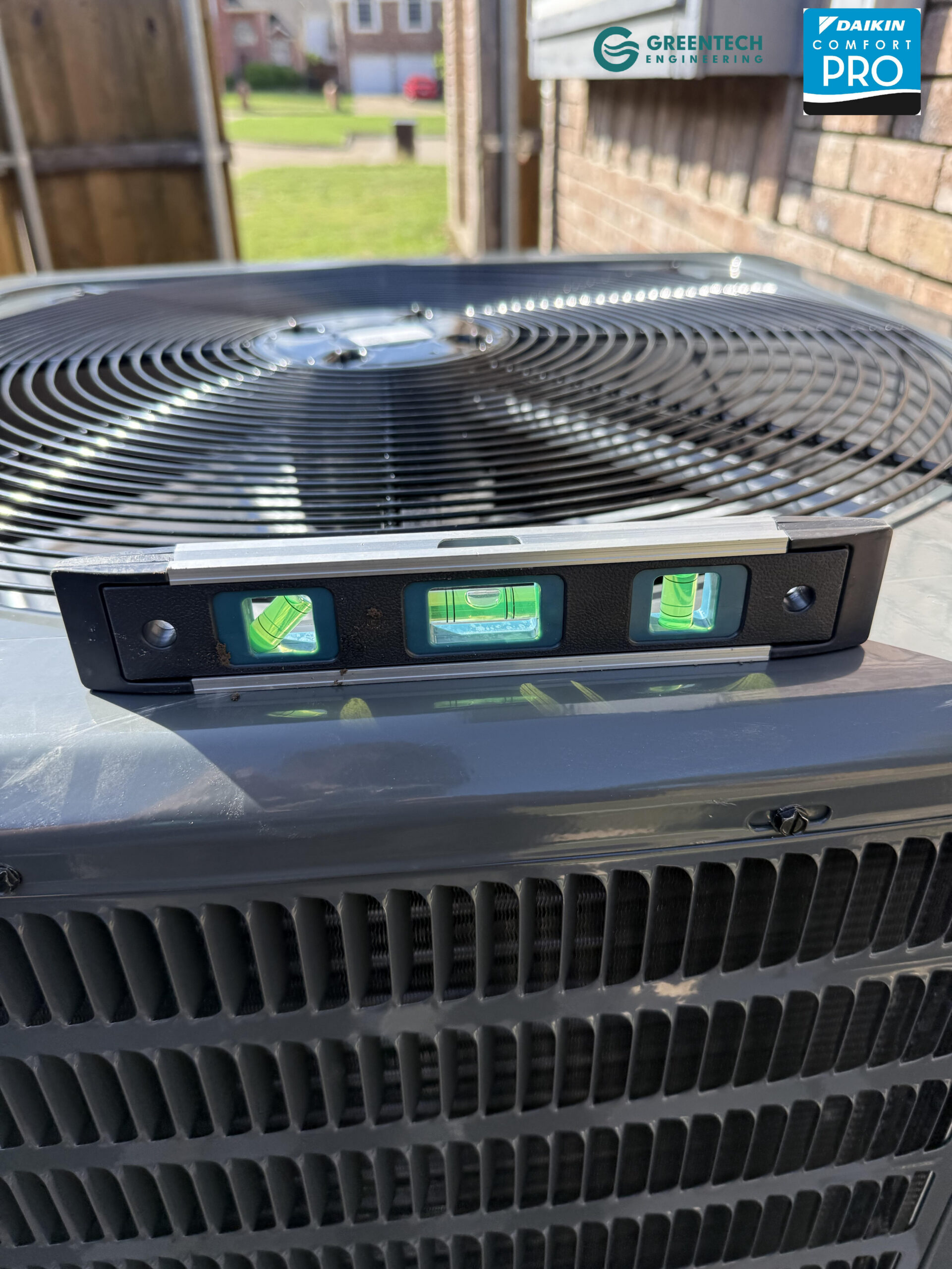 A level resting on top of a newly installed Goodman AC condenser proving a perfectly flat installation.