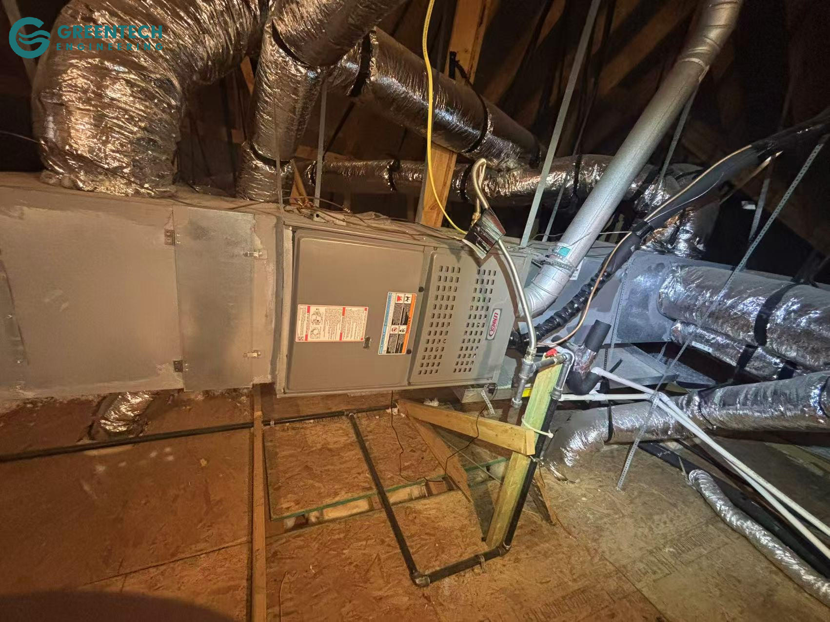 An old Lennox gas furnace installed horizontally in a residential attic surrounded by ductwork.