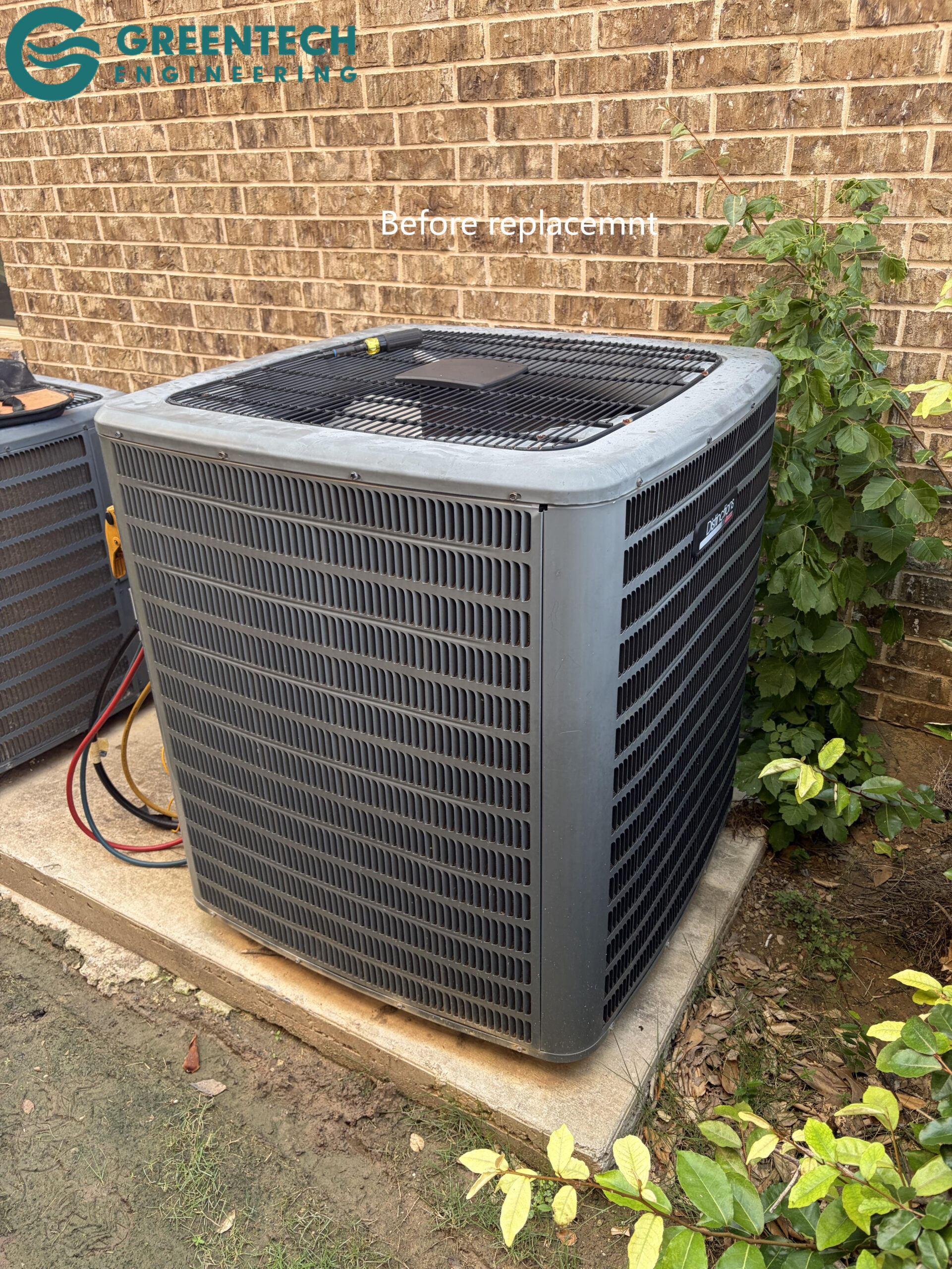 An aging, low-efficiency air conditioning condenser sitting on an old pad outside a residential home in Little Elm, Texas.