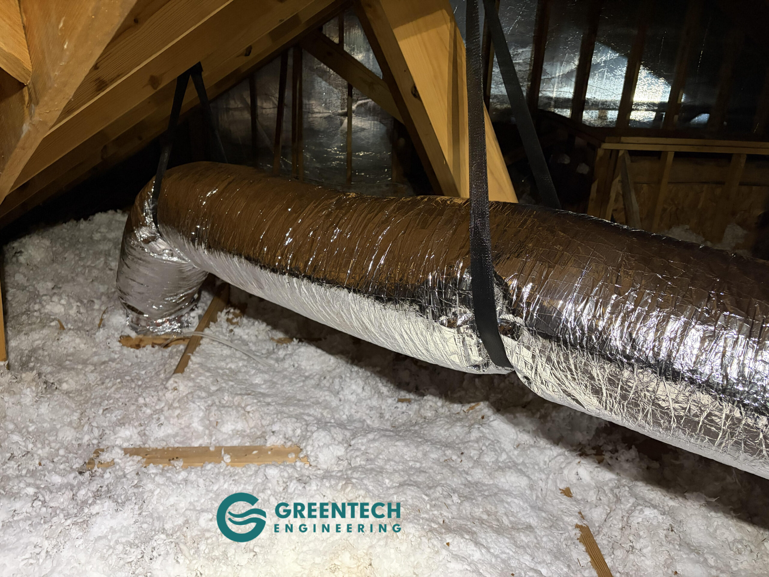 Strapped and insulated flexible HVAC ductwork installed in an attic.