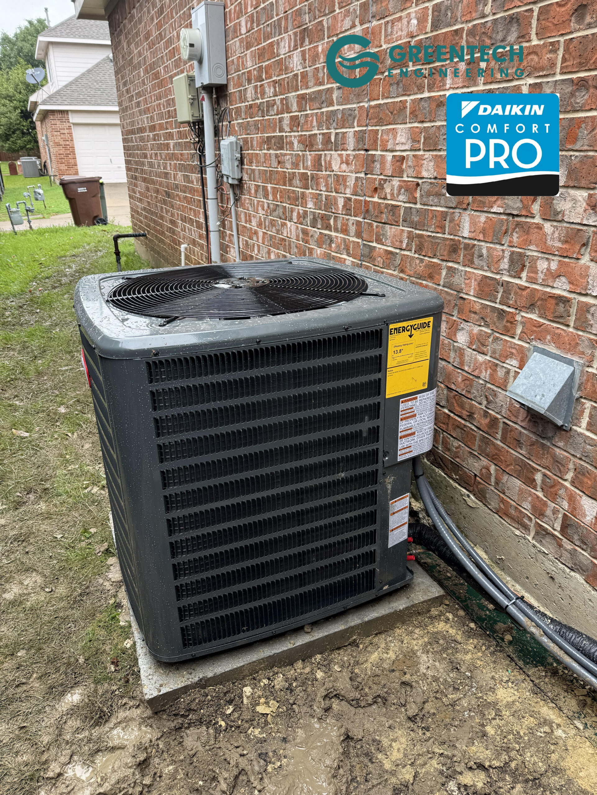 A newly installed, dark gray 4-Ton Goodman 14.3 SEER2 air conditioning condenser sitting on a level pad outside a brick home in Forney, Texas.