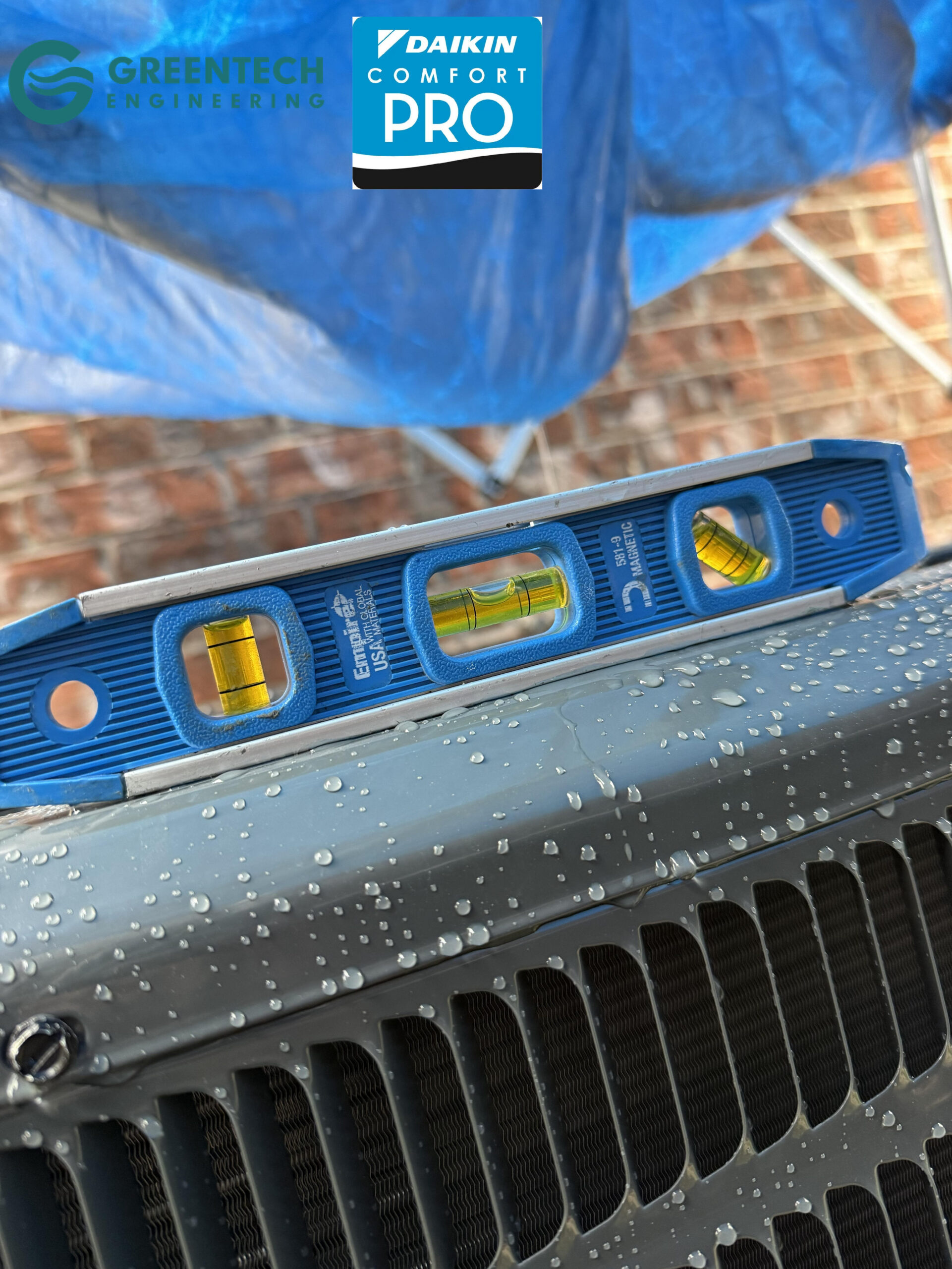 A blue Empire magnetic level sitting on top of a newly installed Goodman AC condenser, ensuring perfectly balanced operation.
