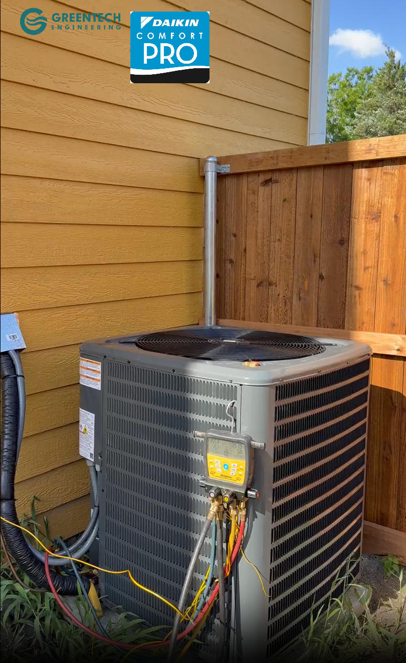 A pristine, high-efficiency Daikin air conditioning condenser installed against the exterior siding of a newly constructed home in Plano, TX, featuring a specialized digital manifold gauge.