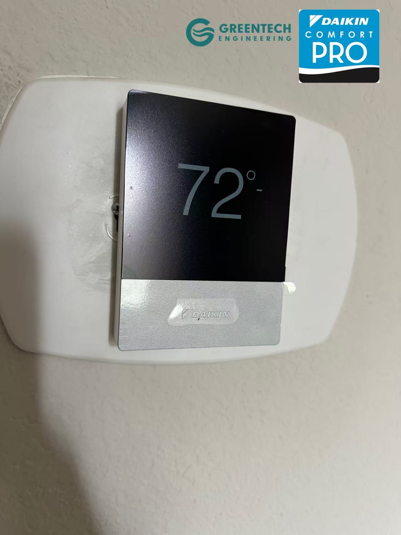A sleek Daikin One+ smart touch screen thermostat mounted on a wall displaying a target temperature of 72 degrees.