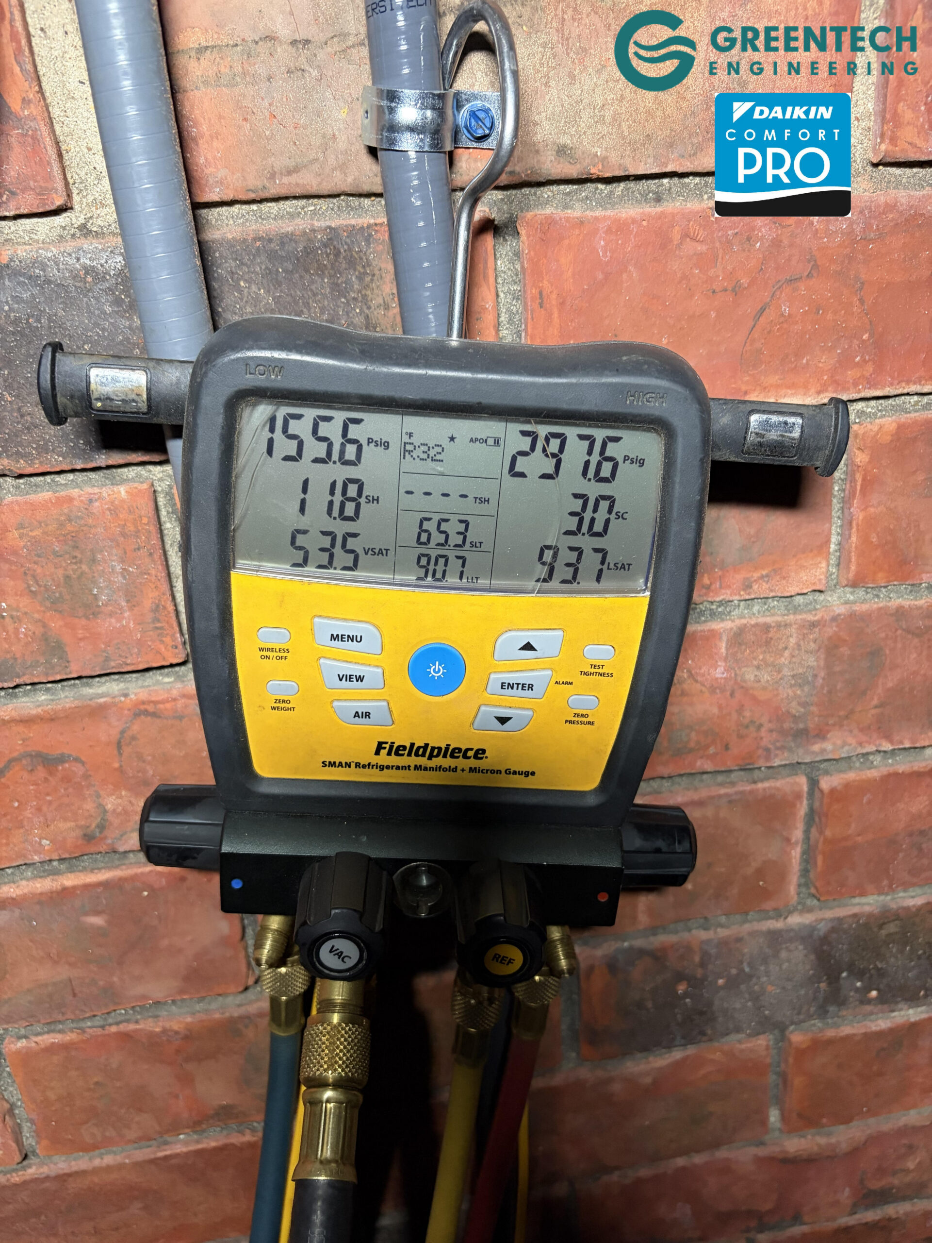 A Fieldpiece SMAN digital refrigerant manifold gauge displaying precise subcooling and superheat pressures during a Daikin Fit startup.