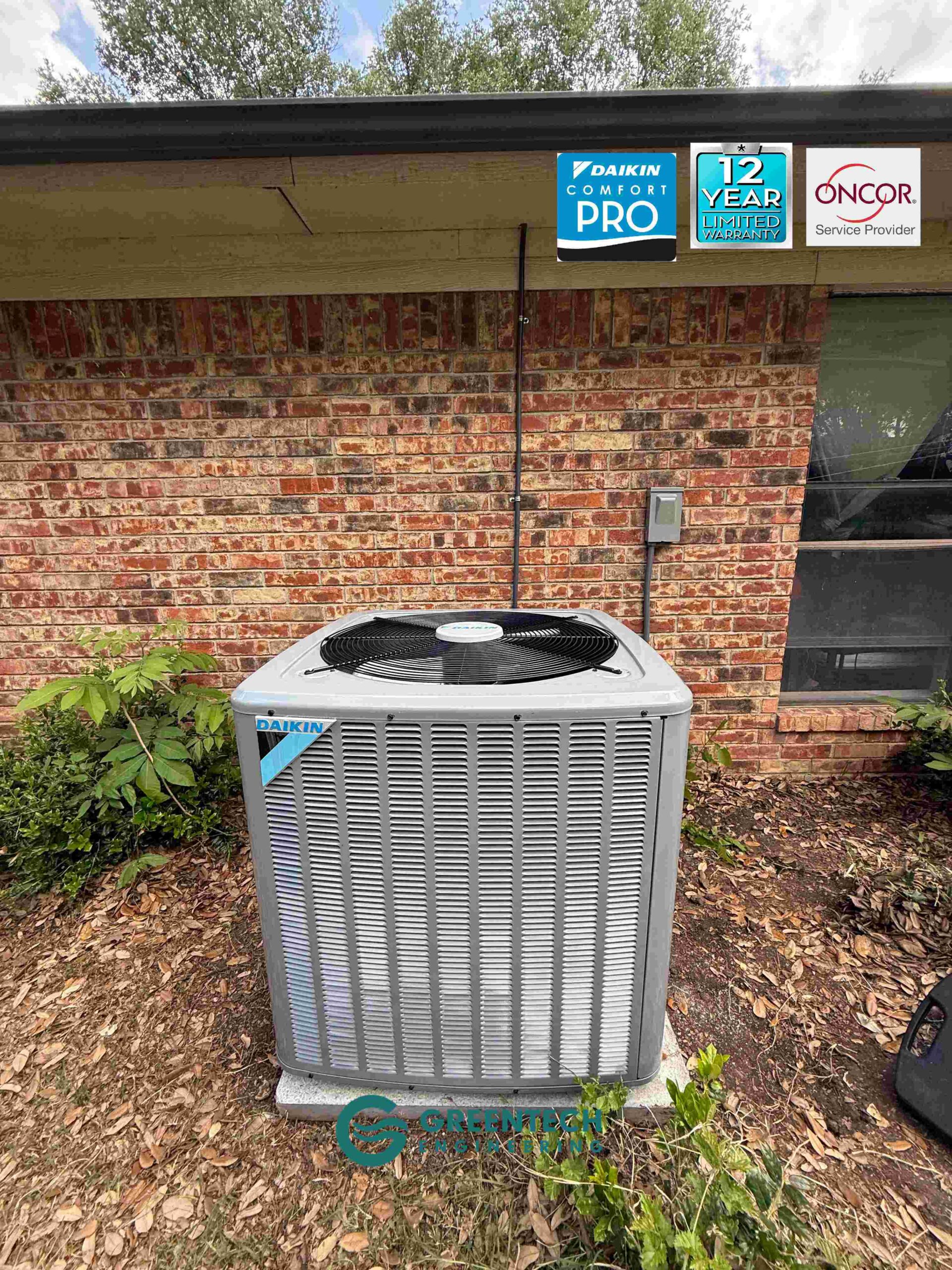 A brand new, gray Daikin heat pump condenser fully installed and leveled outside a brick home in Plano, Texas, featuring Greentech Engineering and Oncor Authorized Provider badges.