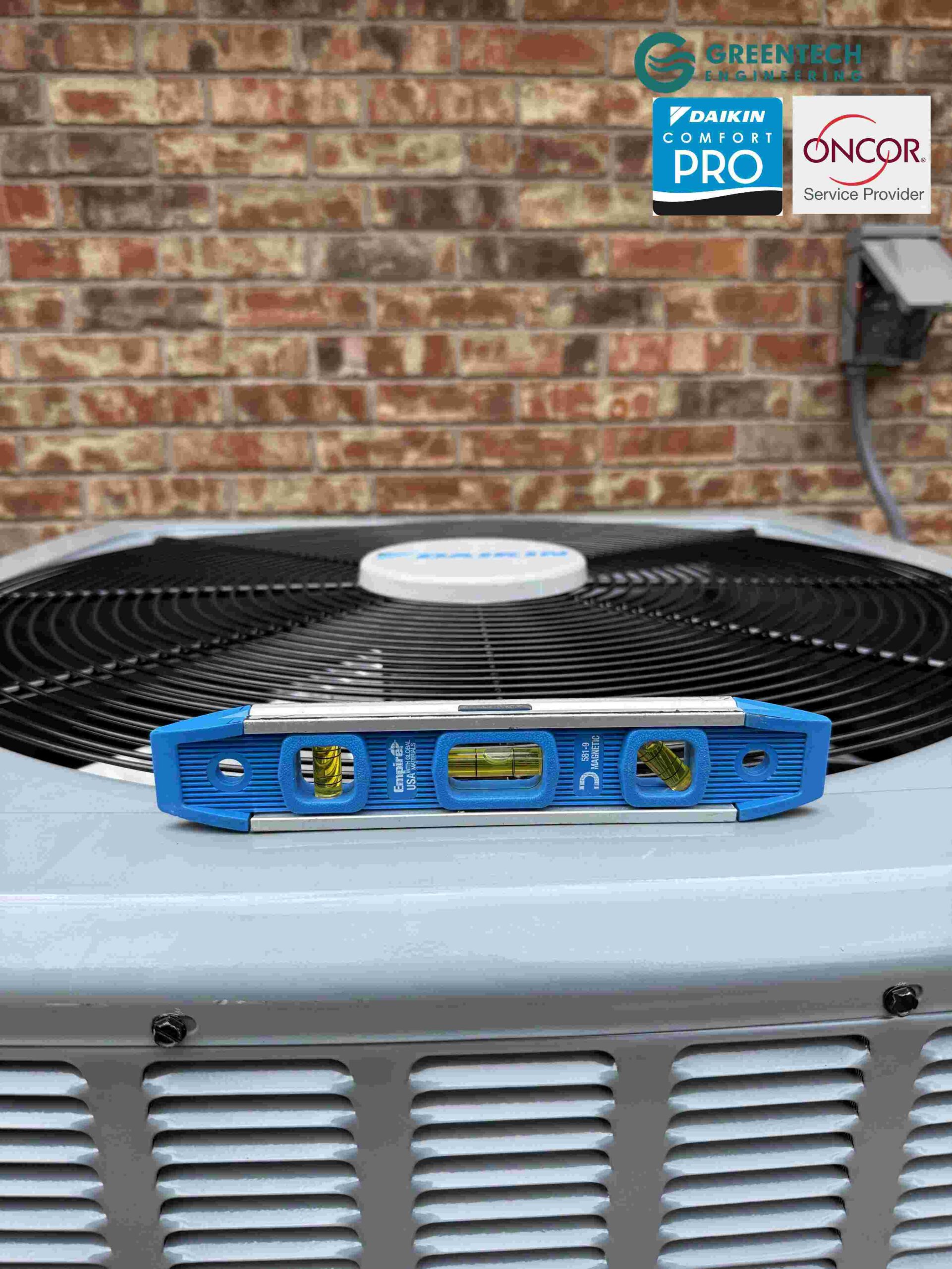 A blue Empire magnetic spirit level sitting perfectly centered on top of a newly installed Daikin heat pump condenser fan guard.