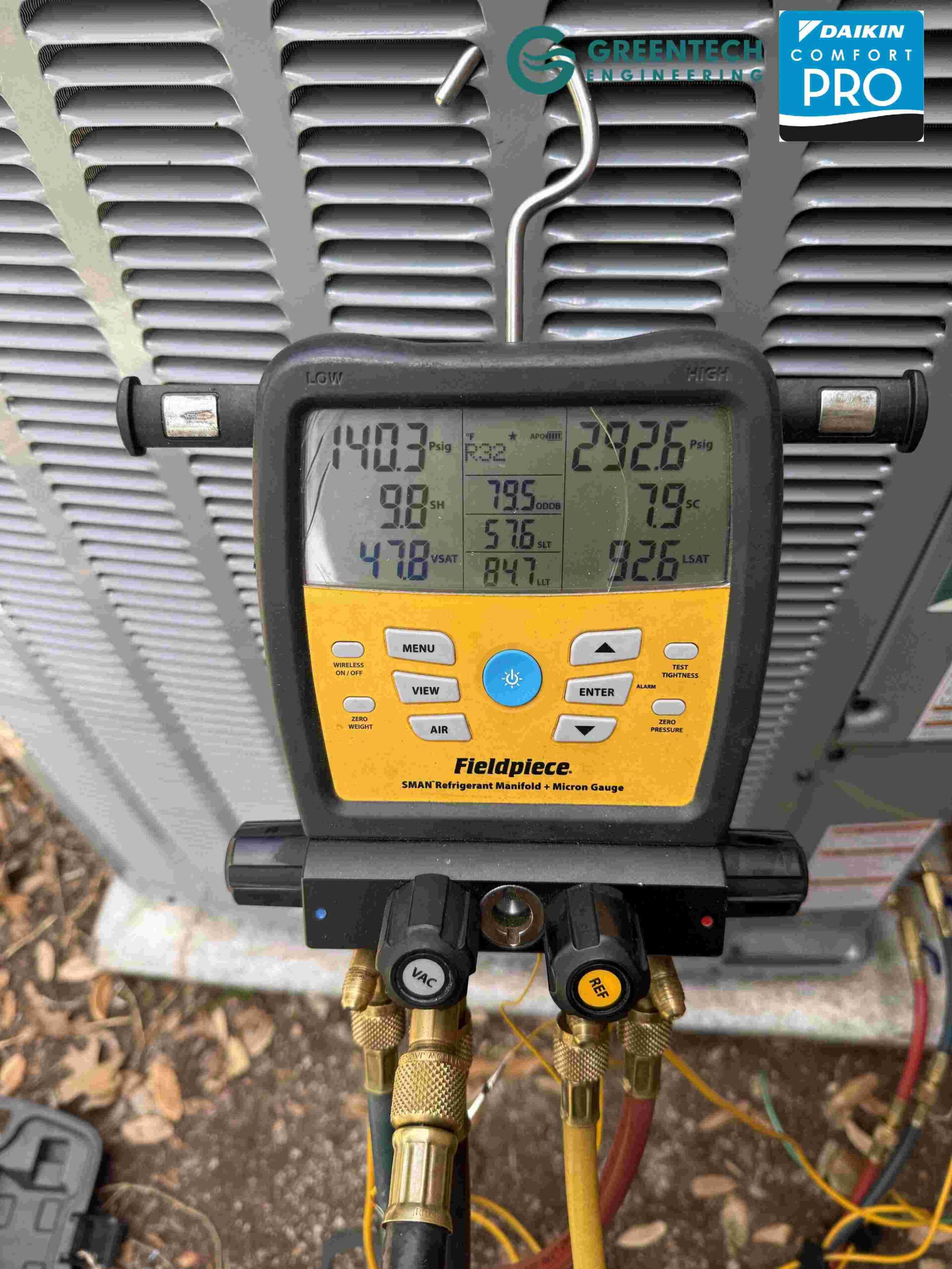 A Fieldpiece digital HVAC manifold gauge connected to refrigerant lines, displaying accurate subcooling and superheat pressures during startup.