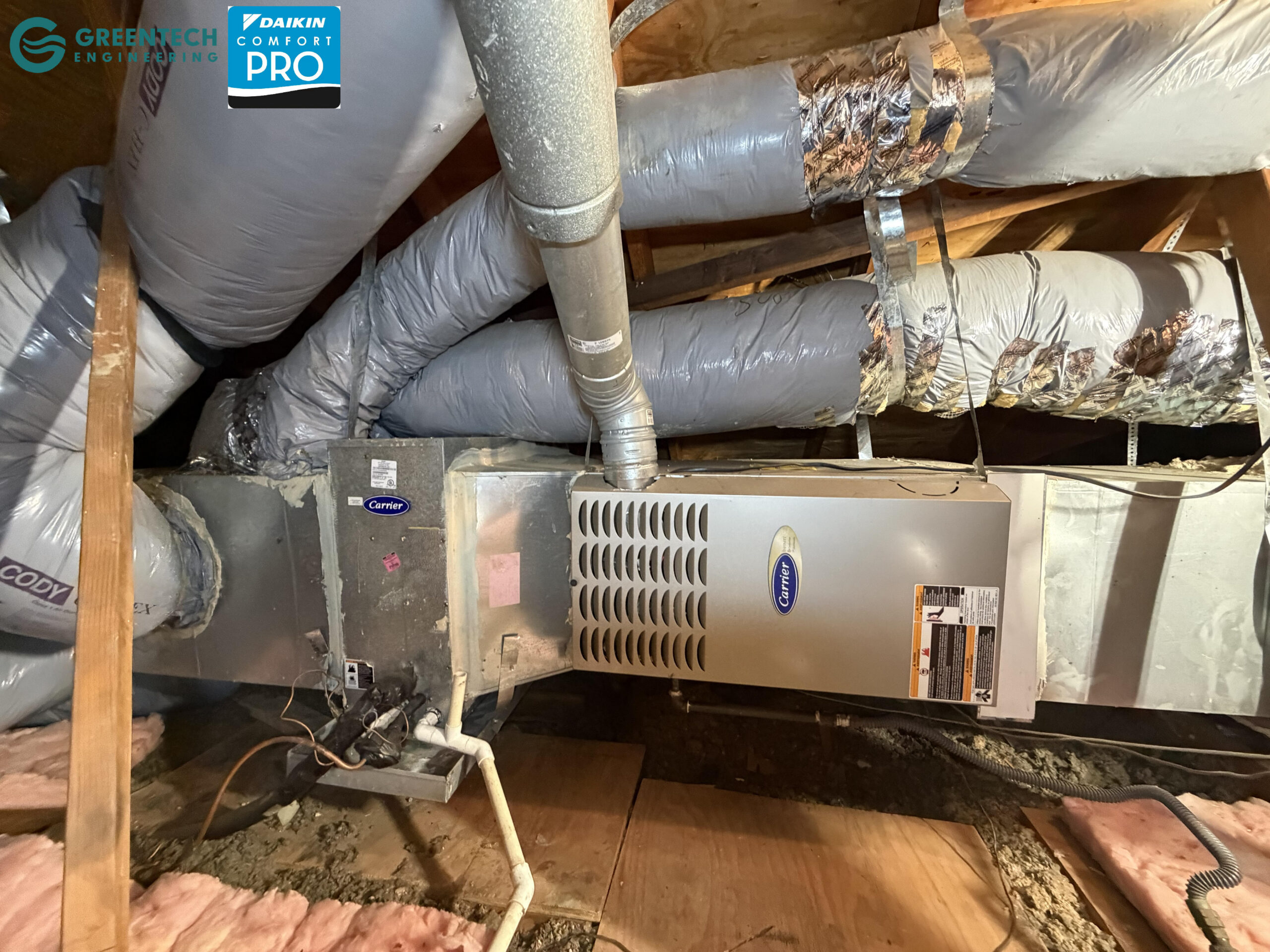 An older Carrier gas furnace and evaporator coil installed in a Plano attic with aging ductwork and poor insulation.