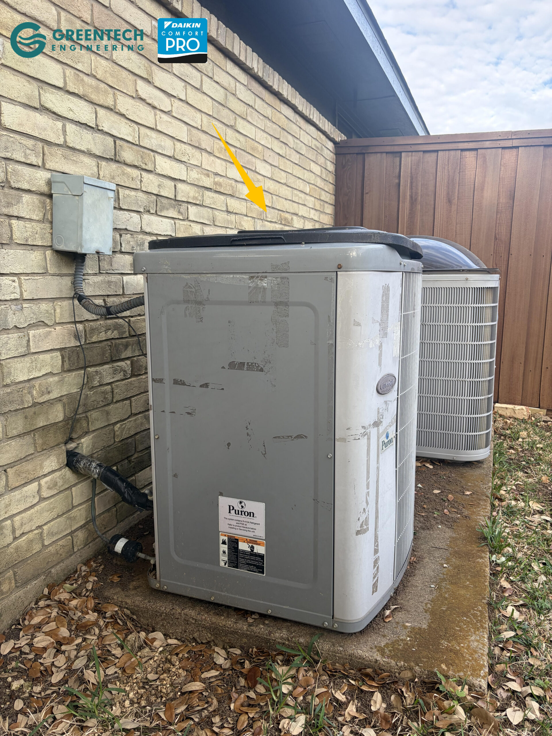An aging, inefficient Carrier AC condenser unit showing significant wear and tear outside a brick home in Plano, Texas.