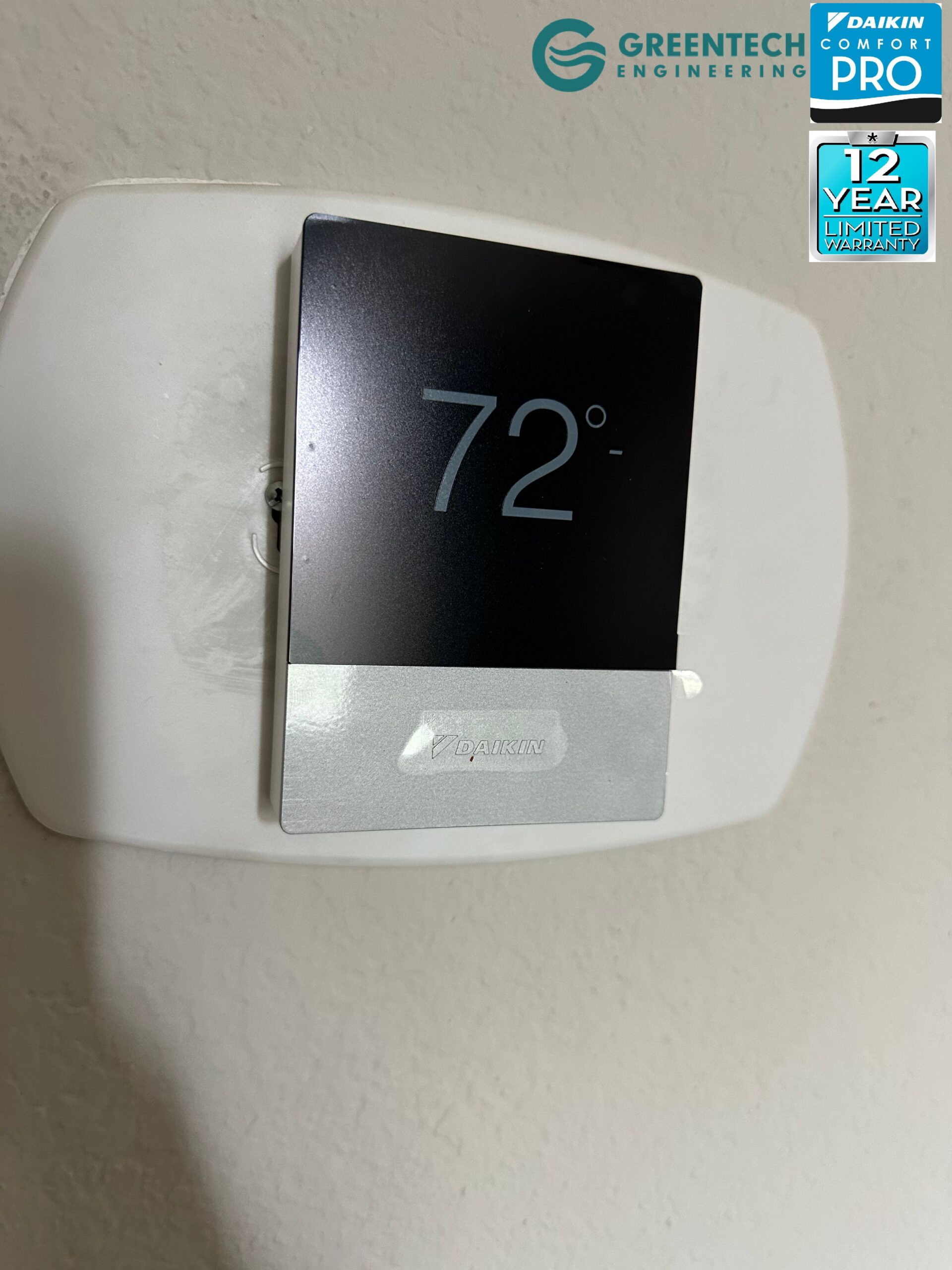 The sleek, modern interface of the Daikin One+ Smart Thermostat mounted on a wall, displaying a precise 72-degree temperature setting.