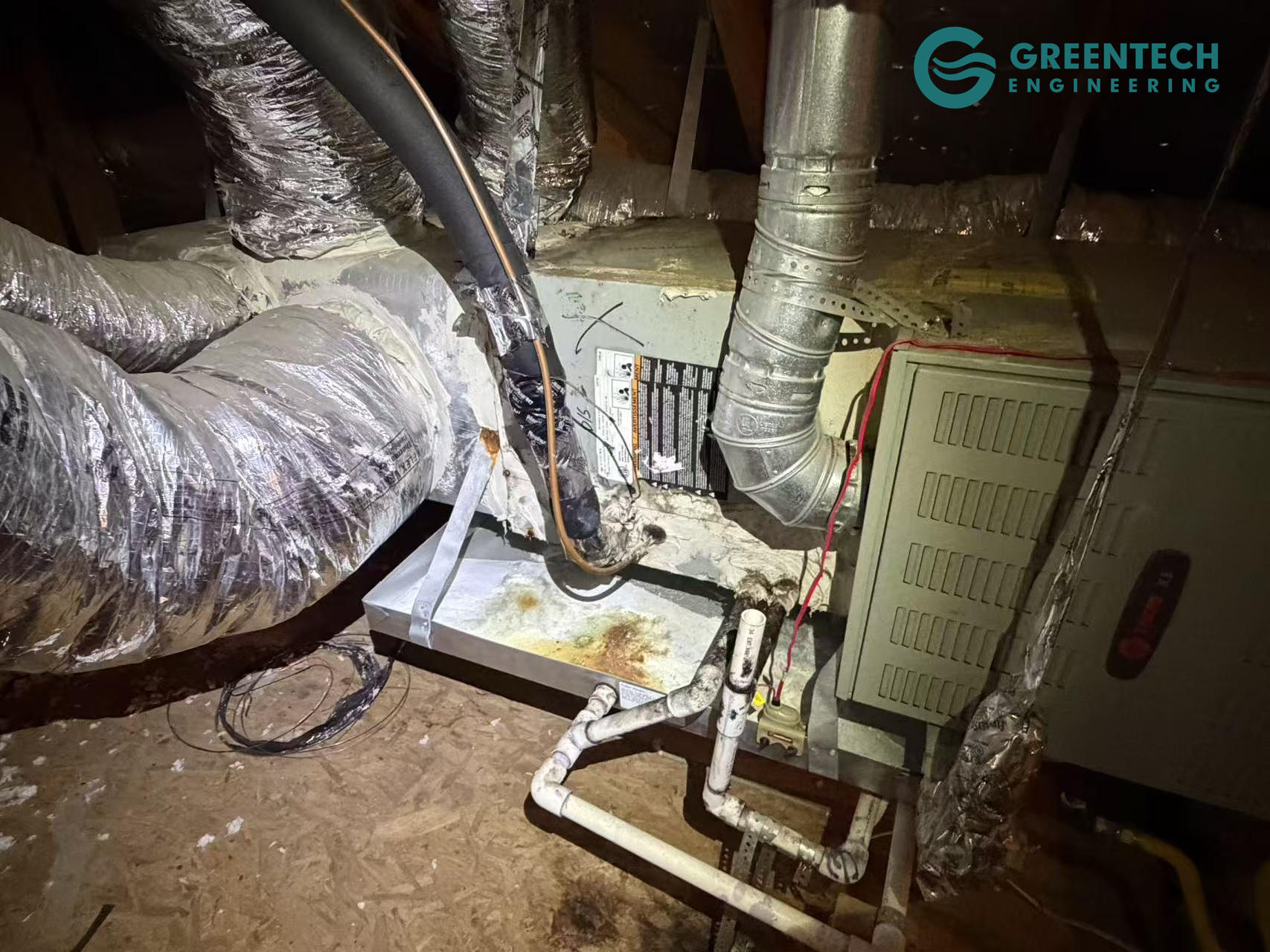An aging, builder-grade indoor HVAC air handler and tangled, poorly insulated flexible ductwork in a Forney, Texas attic.