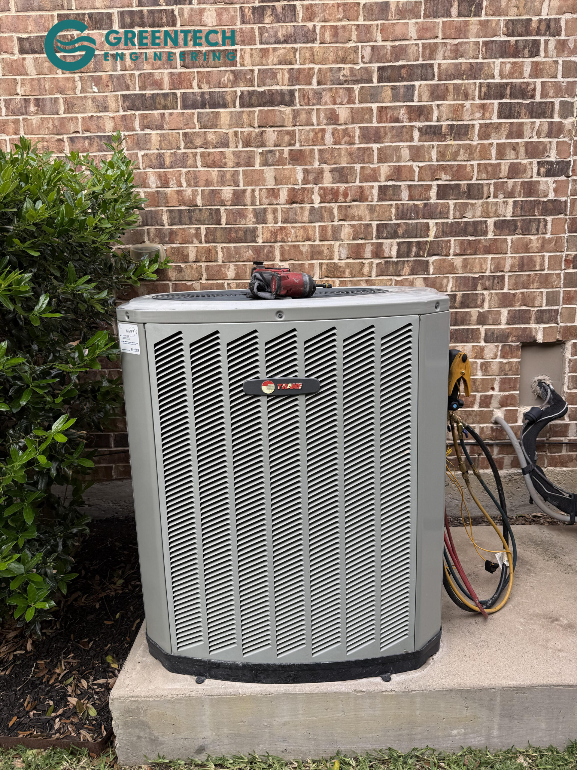A failing, low-efficiency builder-grade Trane air conditioning condenser sitting on a concrete pad in Forney, TX.