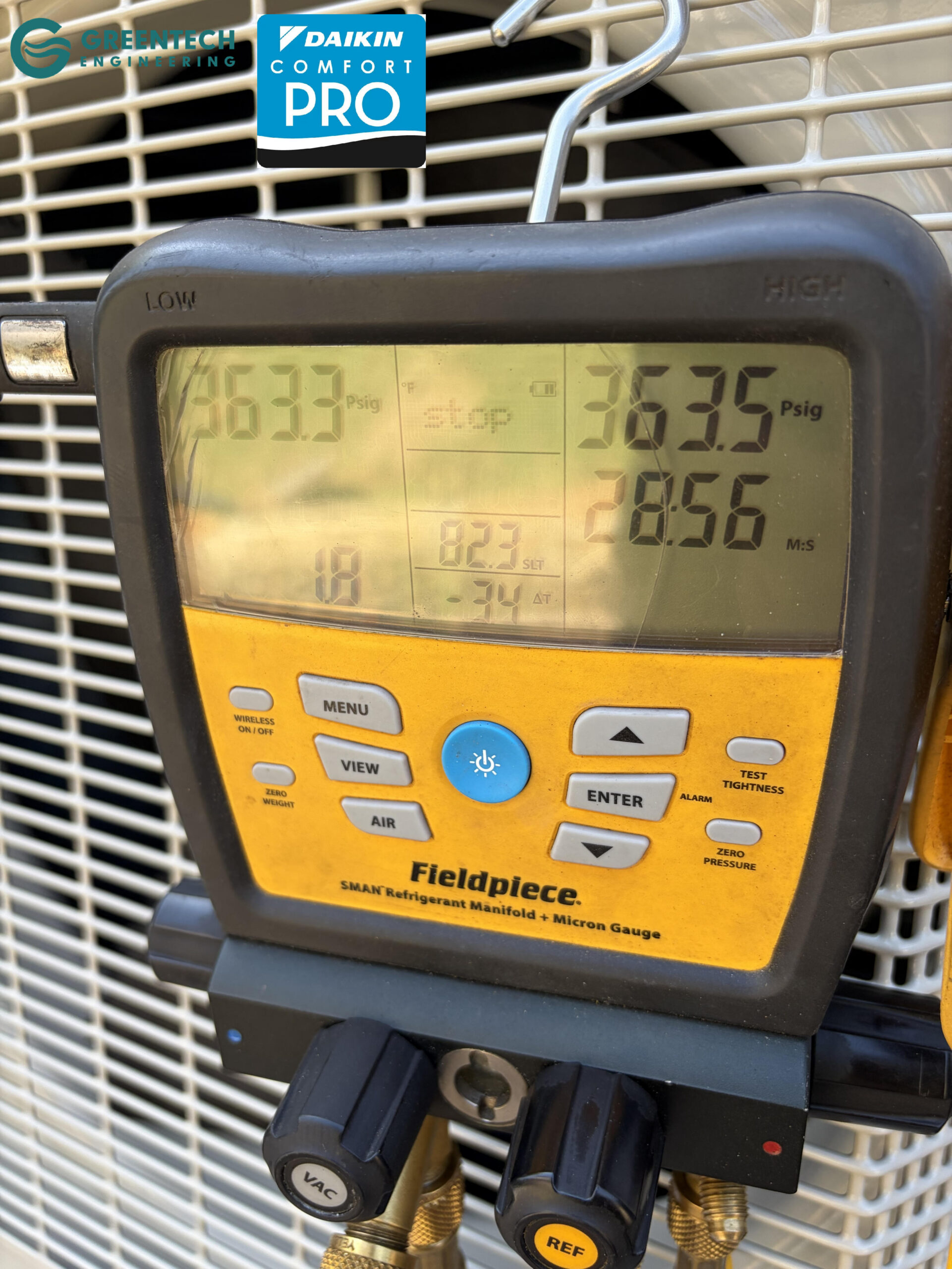 Greentech Engineering technician using a Fieldpiece digital manifold gauge to perform a high-pressure nitrogen leak test at 363 PSI on a new Daikin installation.