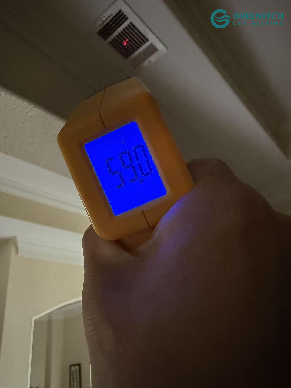 An infrared digital thermometer pointed at an indoor HVAC ceiling vent, displaying a perfectly chilled supply air temperature of 59.0 degrees Fahrenheit.