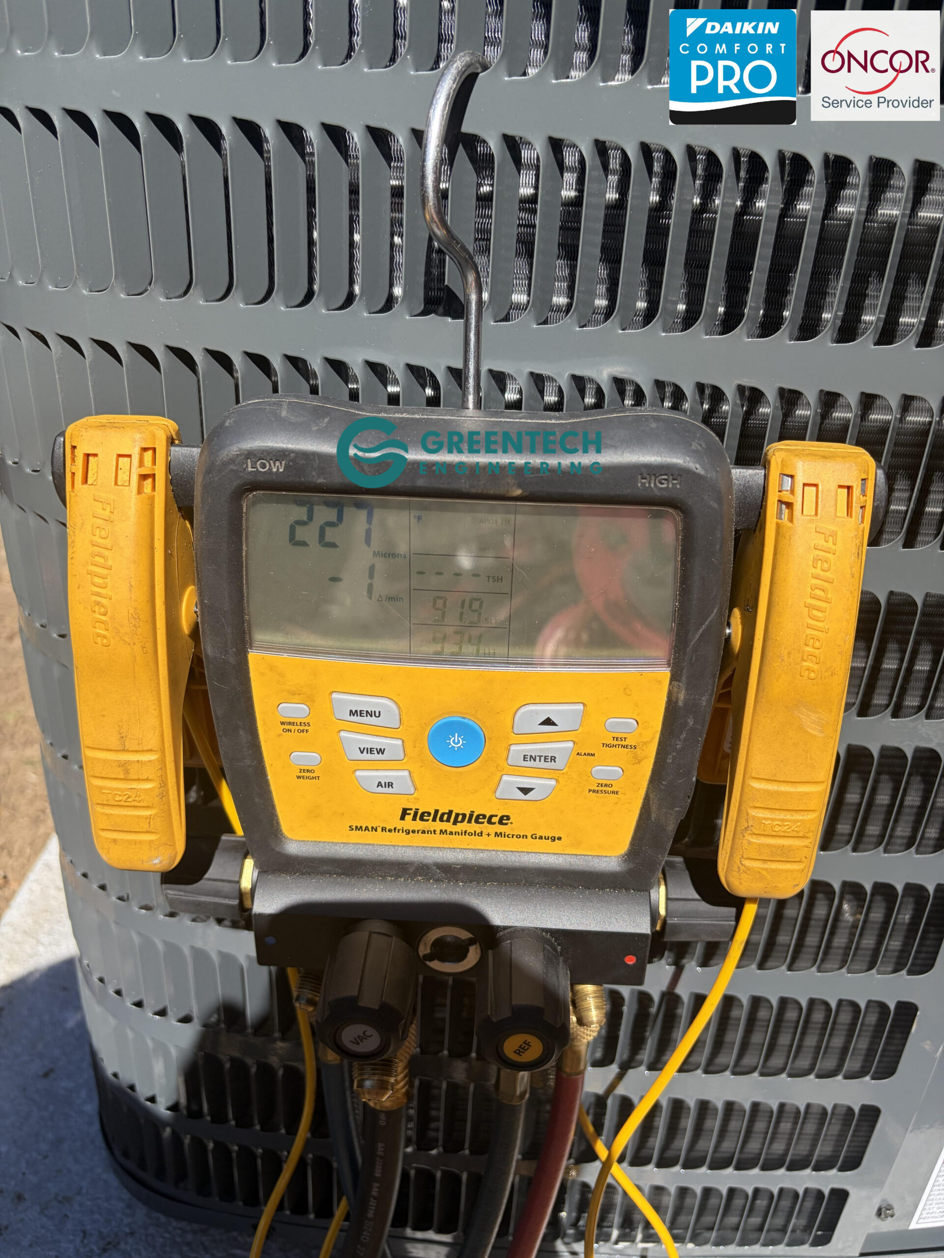 Greentech Engineering utilizing digital Fieldpiece manifolds to diagnose refrigerant pressures on an AC system.