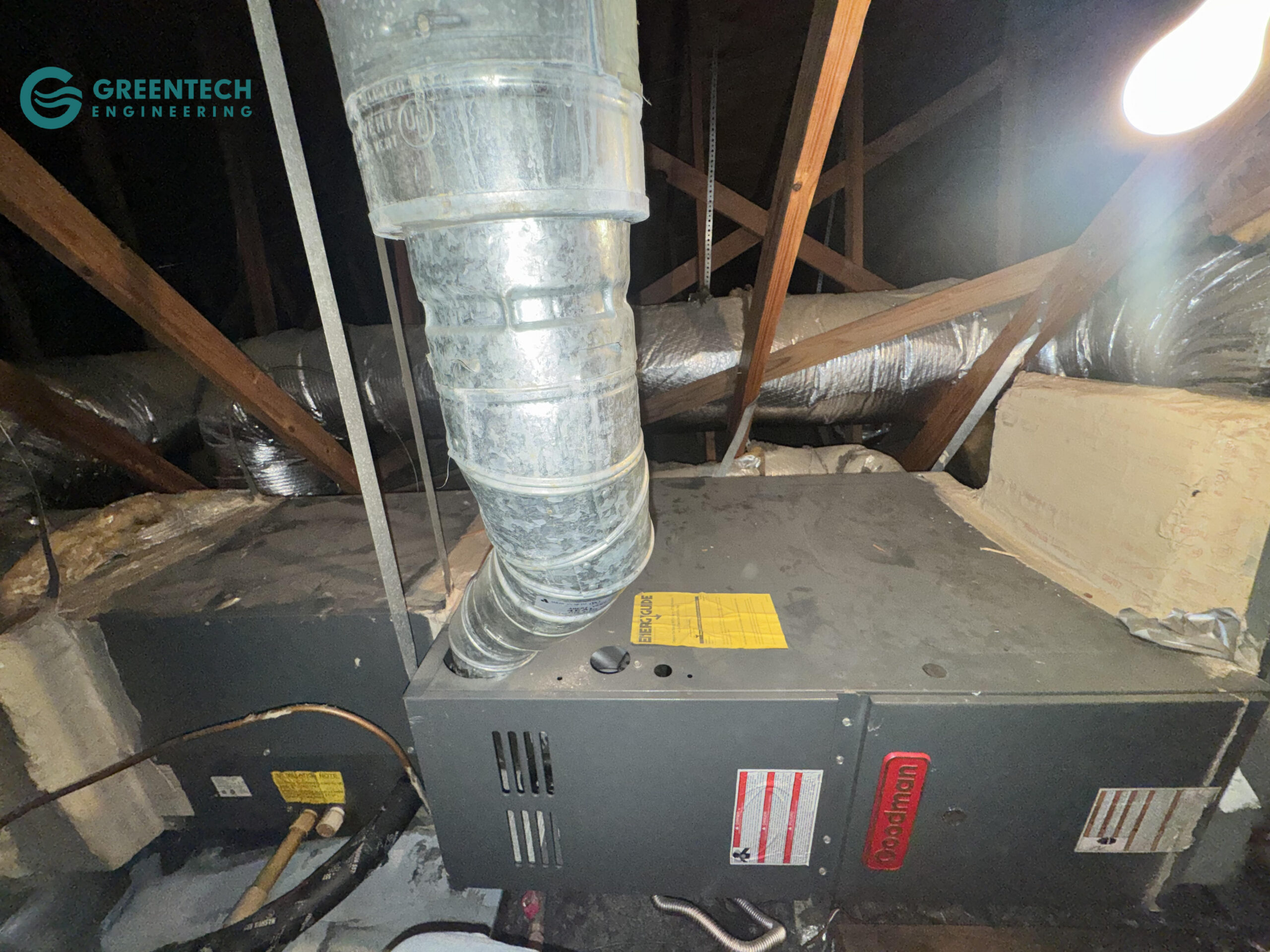 An aging, low-efficiency Goodman HVAC air handler struggling to push air through restrictive, poorly designed ductwork in a hot Dallas attic.