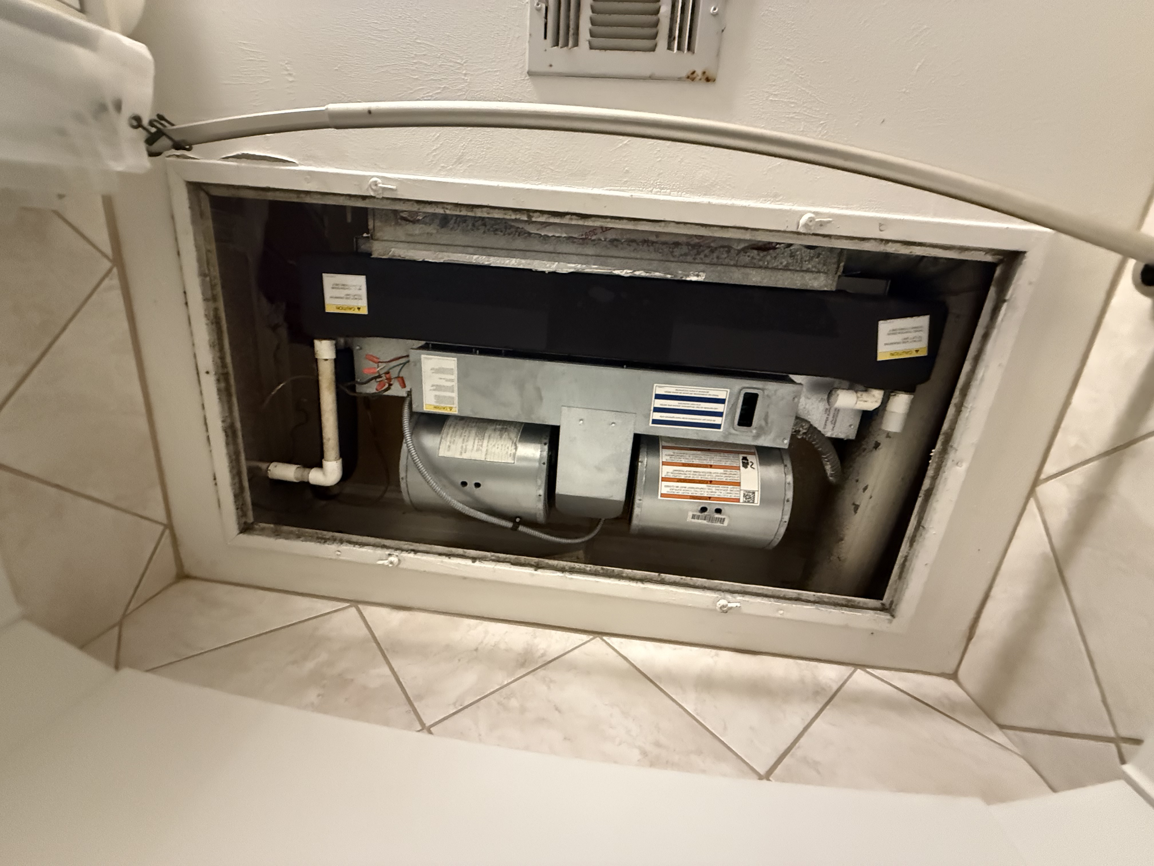 Existing ceiling-mounted fan coil before heat-pump replacement in Dallas