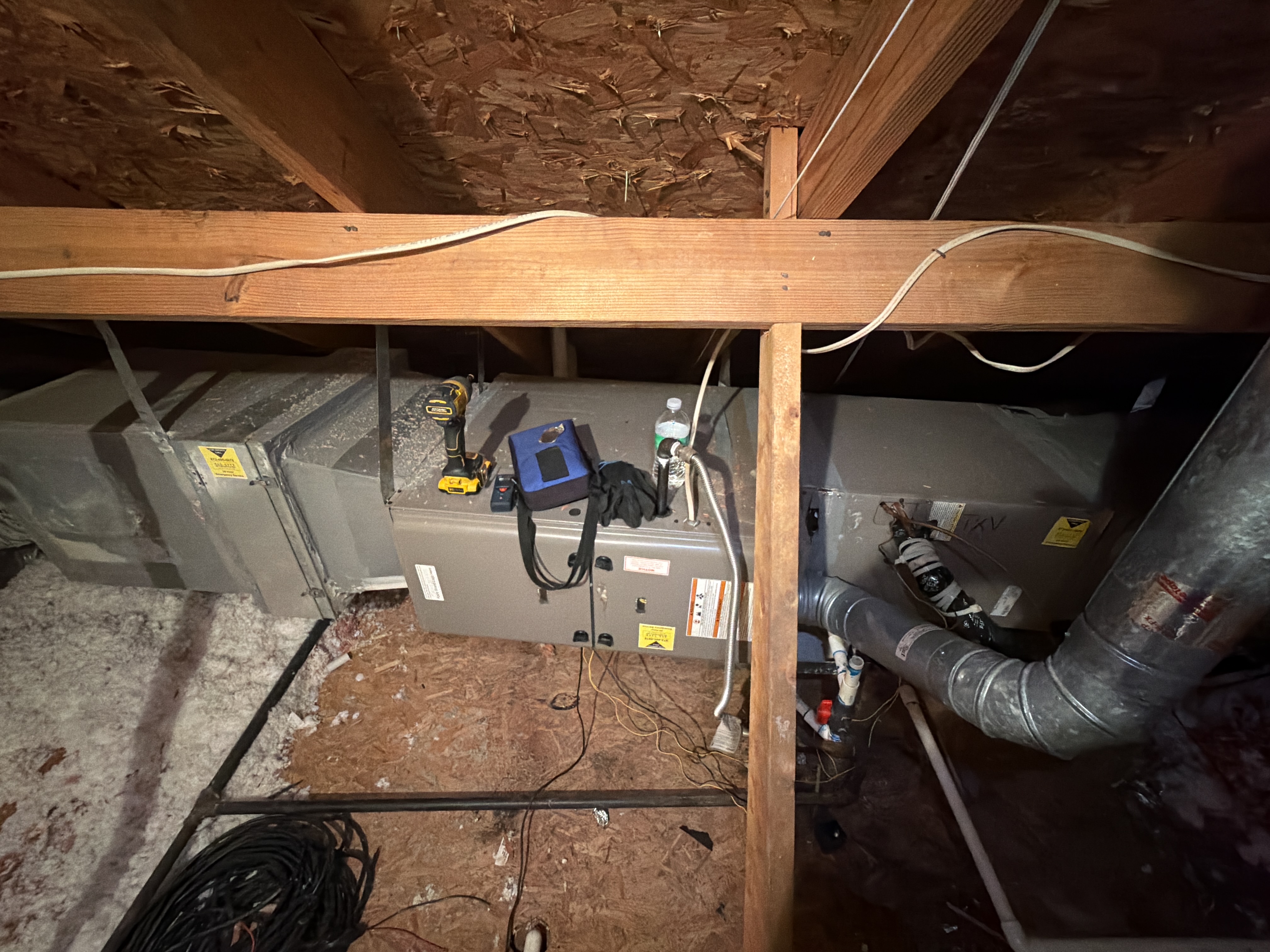 Older downstairs horizontal HVAC equipment in a Plano attic before replacement