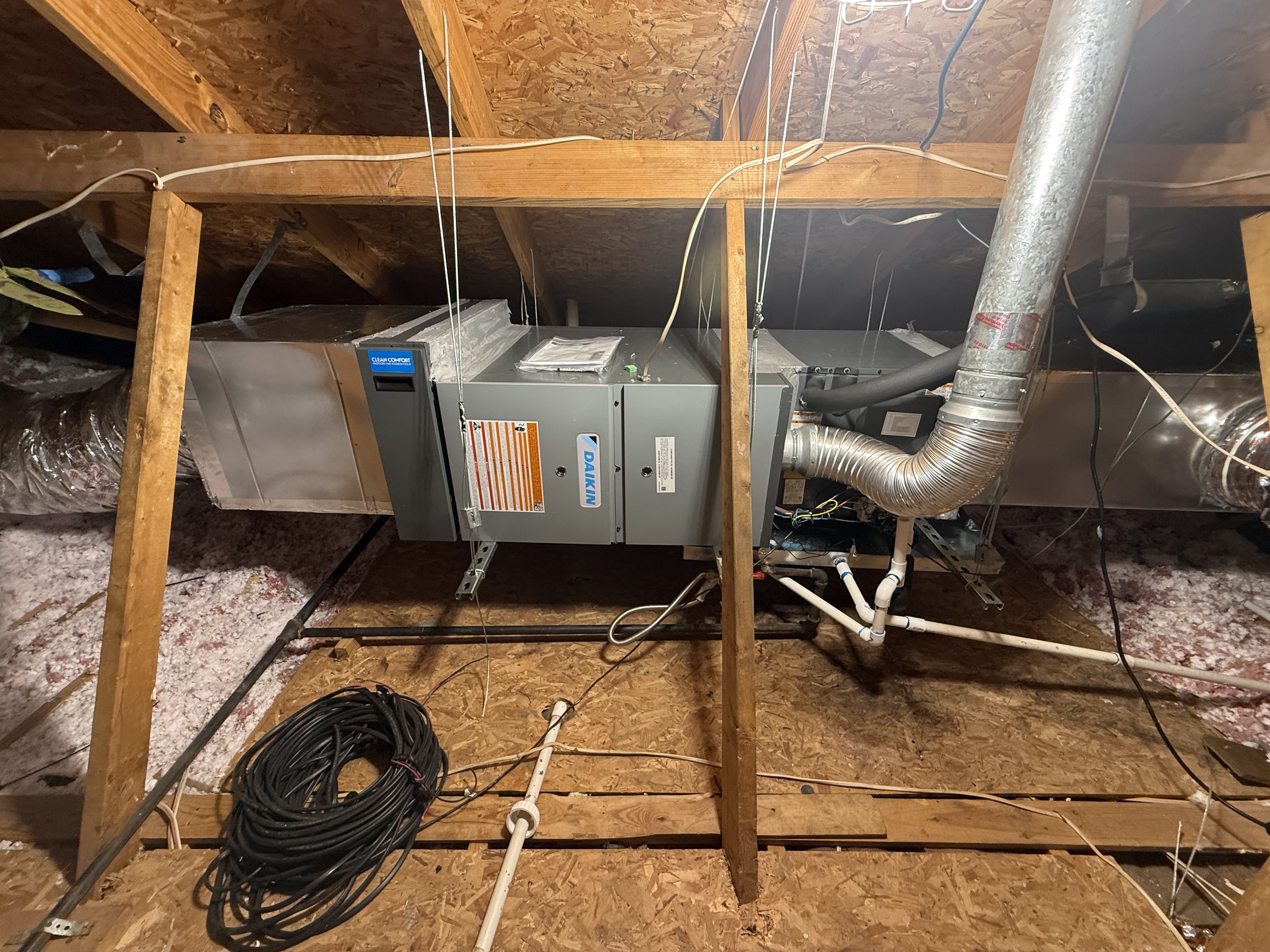 Older downstairs horizontal HVAC equipment in a Plano attic before replacement
