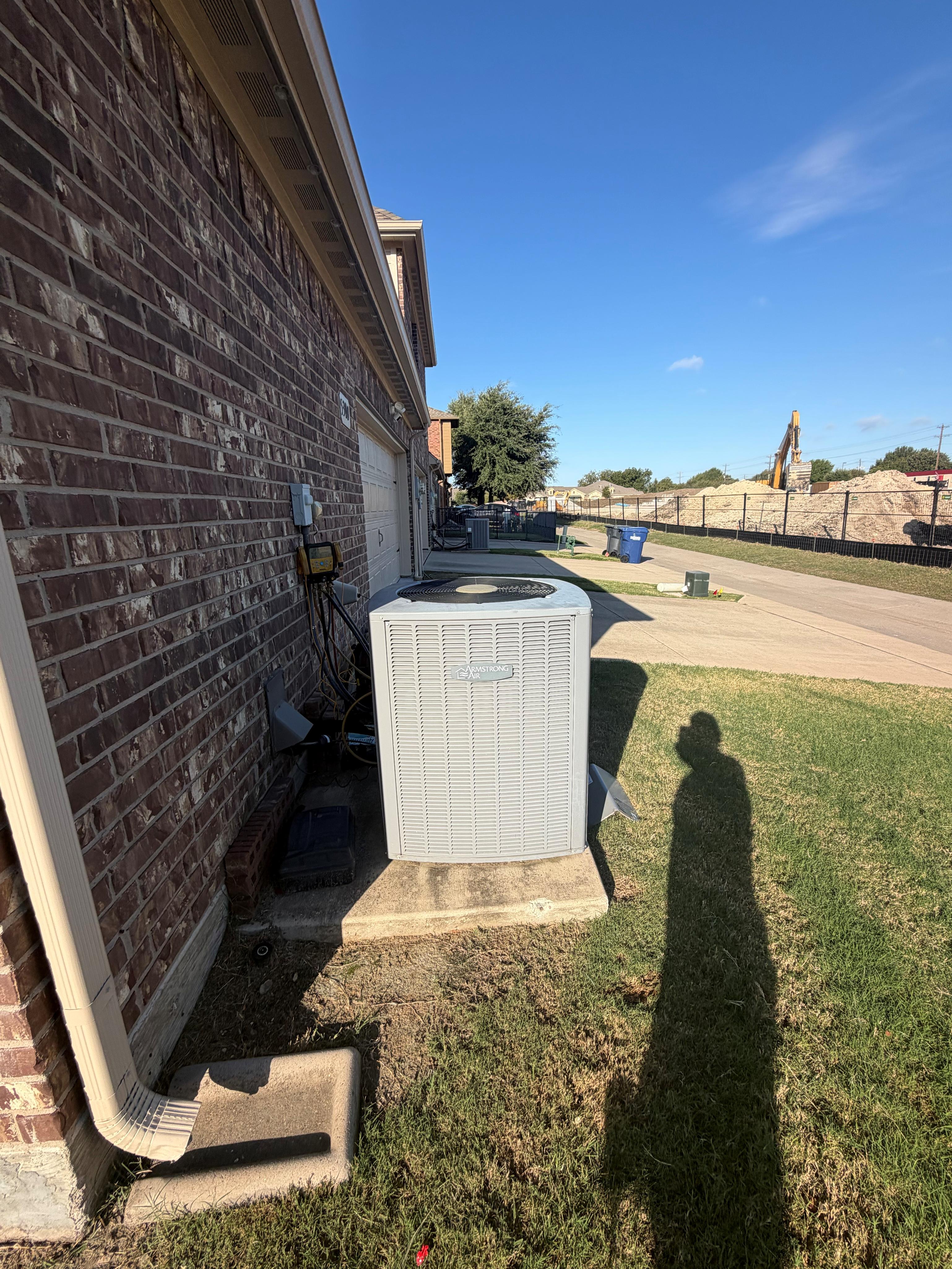 Existing Armstrong Air outdoor condenser at a two-level McKinney home before HVAC replacement.
