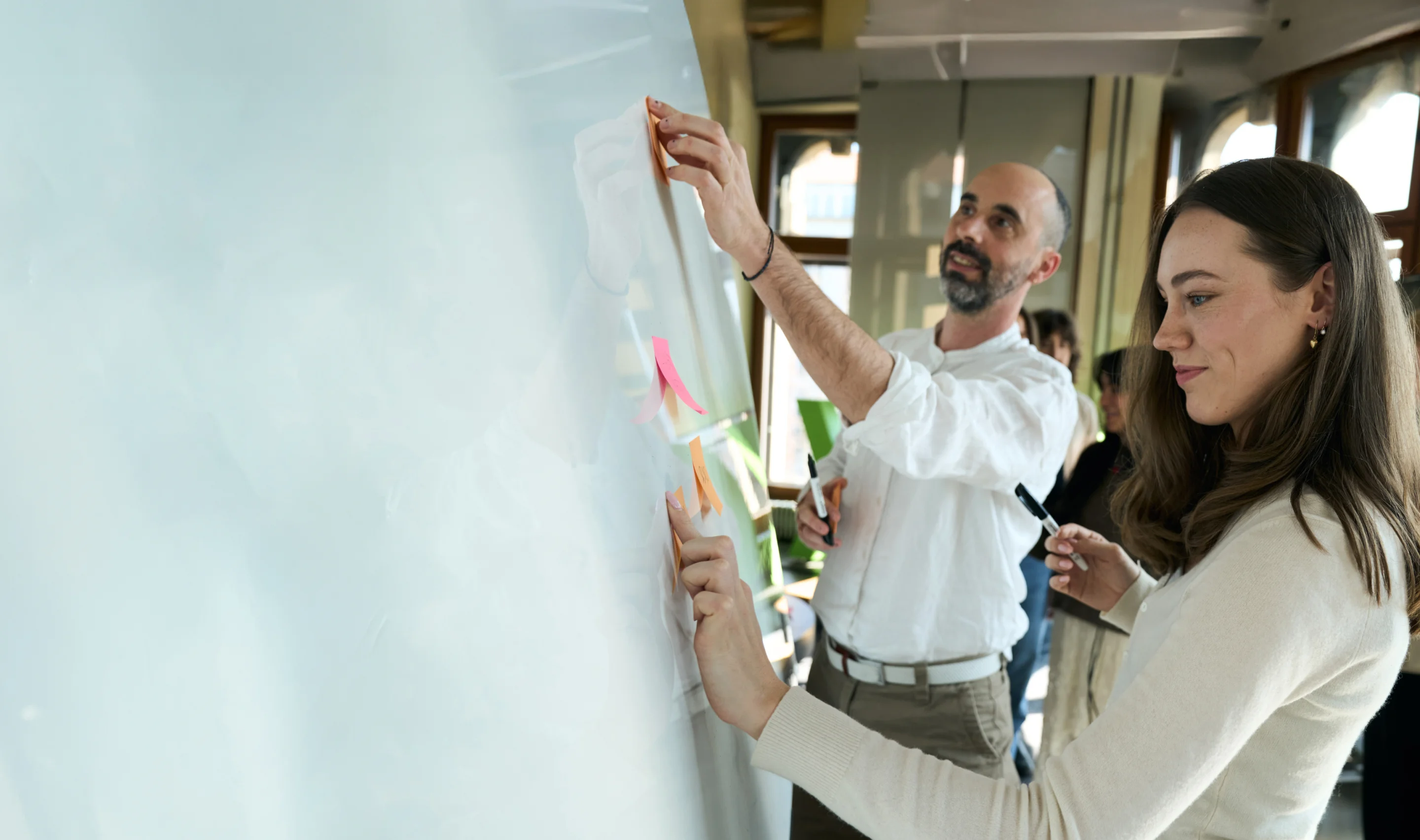 Two people brainstorming on a whiteboard