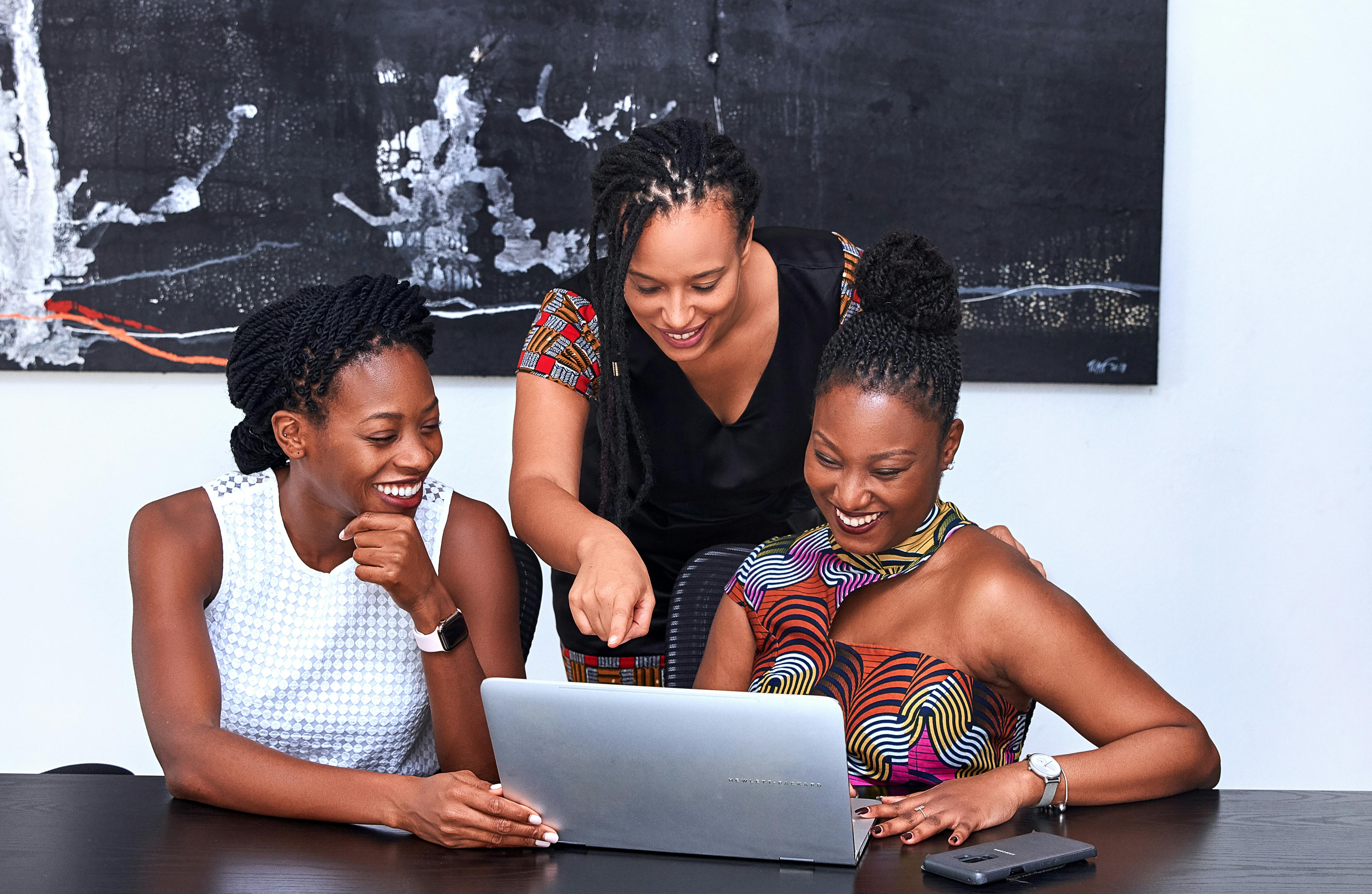 Three African American ladies looking at laptop