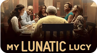Six people, a multi-generational family, having dinner together at a table with 'My Lunatic Lucy' branding.