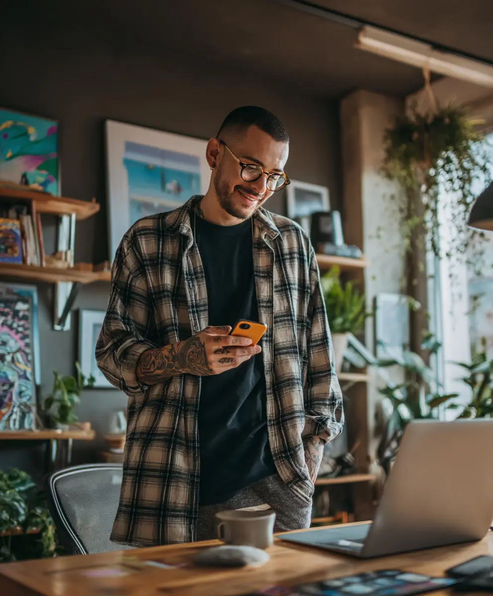 Emprendedor usando app para recibir pagos con tarjeta con su celular desde su casa.