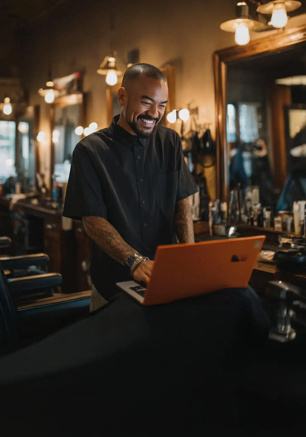 Barbero usando laptop para cobrar con tarjeta en su barbería con Payphone.