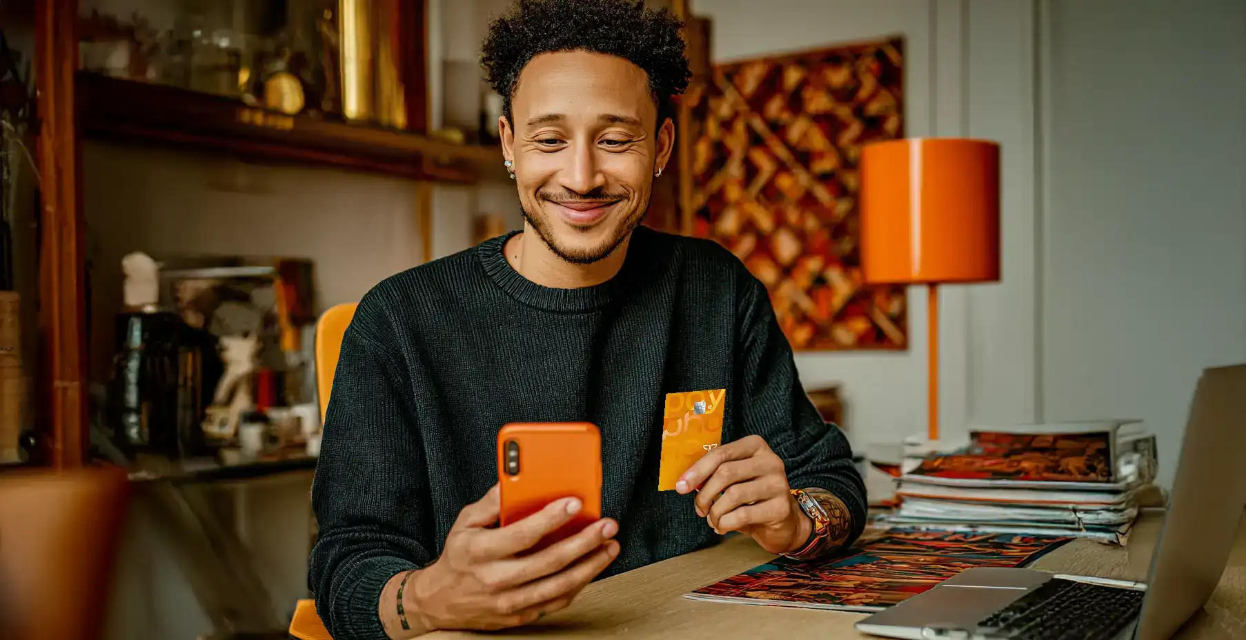 Hombre joven sostiene su tarjeta Mastercard Payphone mientras conoce como activarla en la app.