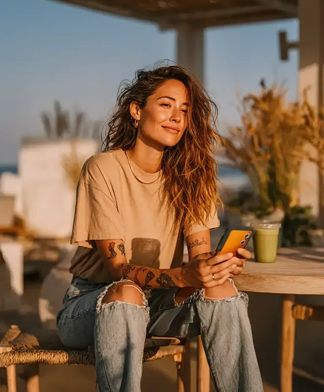 Mujer se encuentra sentada con su smartphone utilizando la app de Payphone.