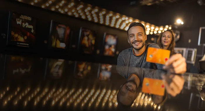 Pareja utiliza su Mastercard Payphone en el cine para acceder a las promociones.