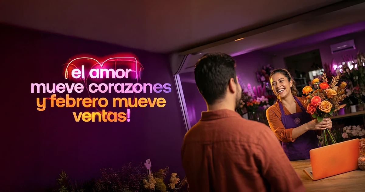 Emprendedora recibiendo flores de un hombre en el mostrador de su negocio