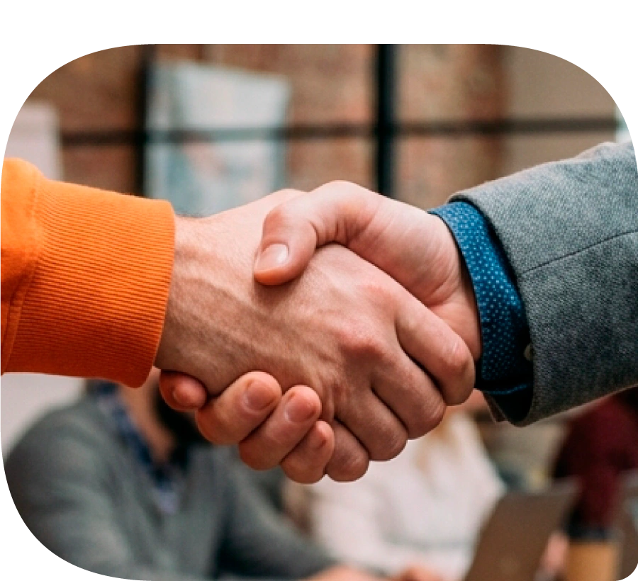 Dos manos de hombres estrechándose, cerrando un trato en una oficina.