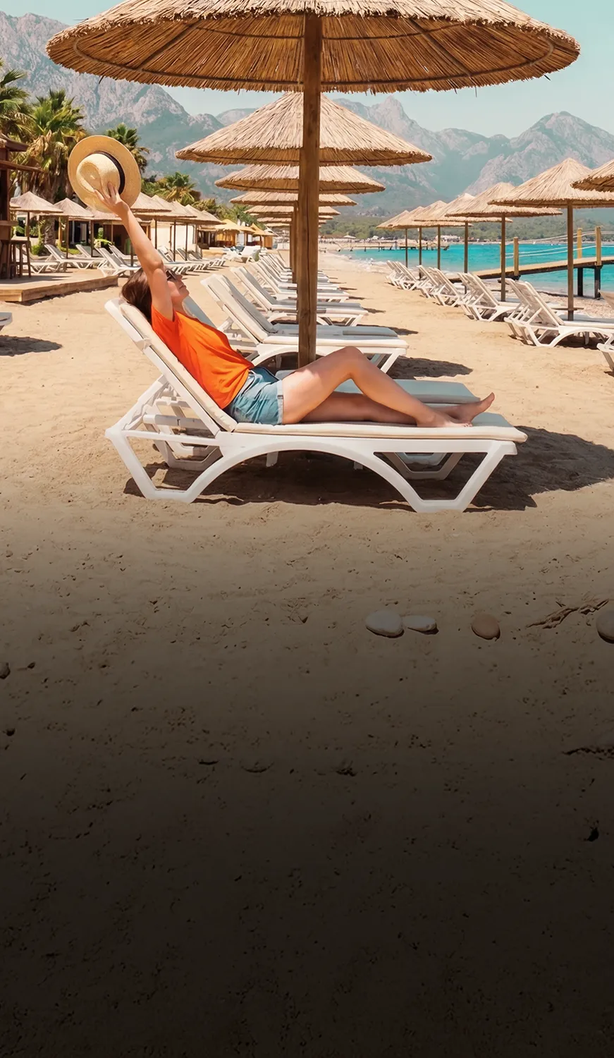 Propietaria de renta vacacional descansando en una playa con sombrillas, representando el cobro sin LLC con API Rentals de Payphone.