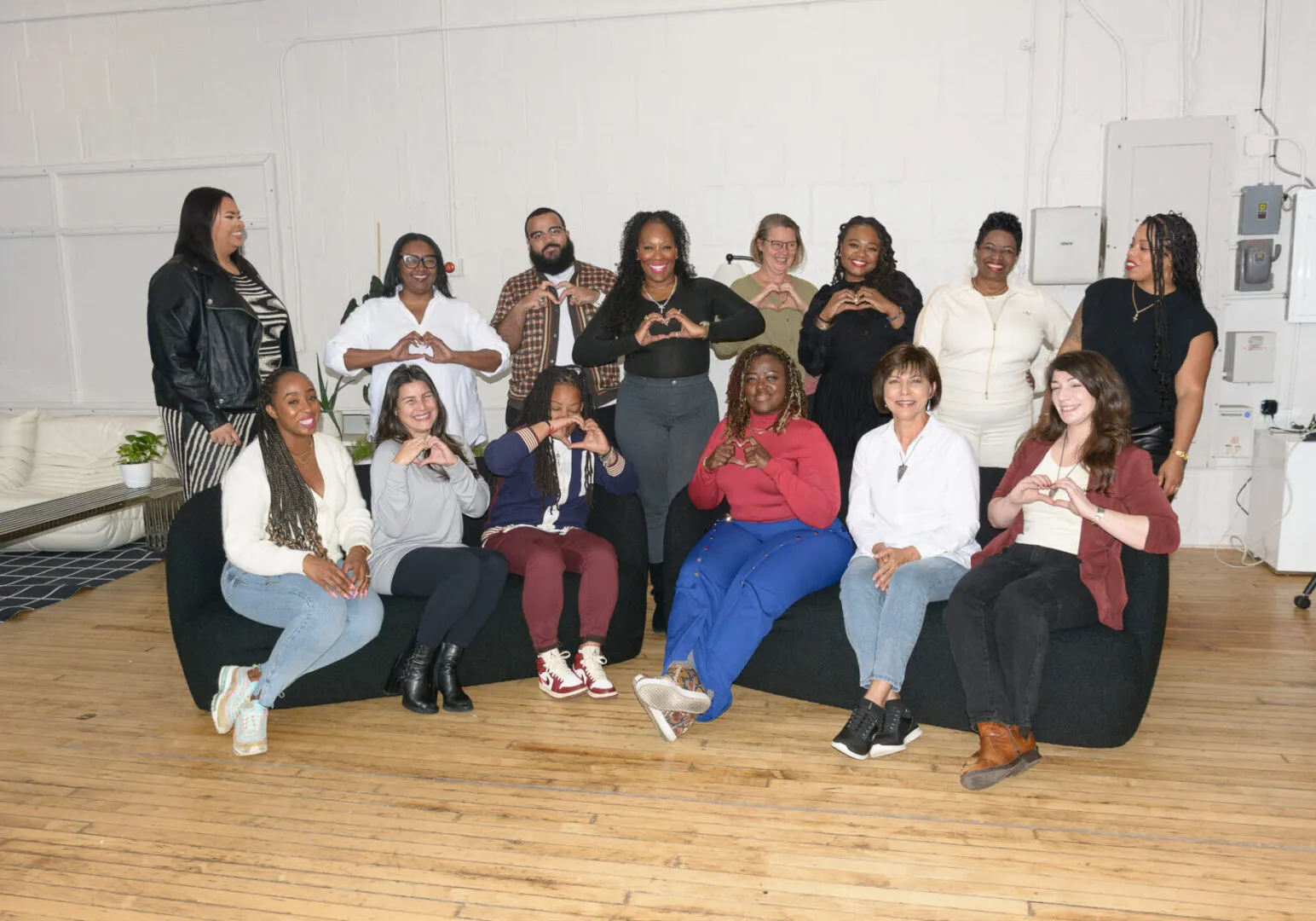 Team Love group photograph of 14 members of The LOHM staff each giving a heart symbol with their hands