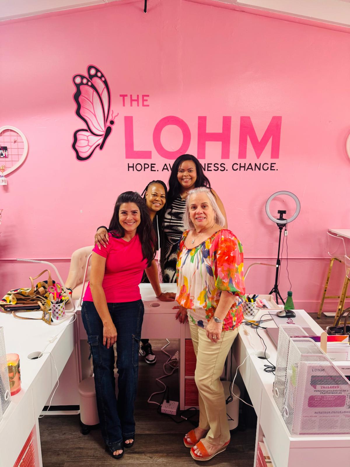 Four female LOHM employees in a pink Florida office