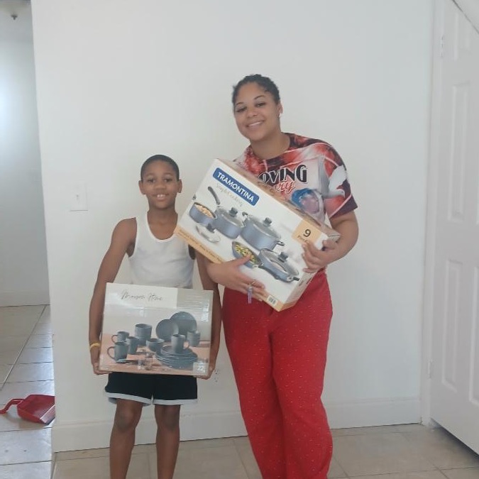 Mother and son proudly displaying new dishes and pots and pans set still in the boxes