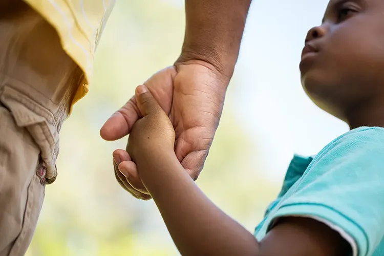 Young son holds his father's hand