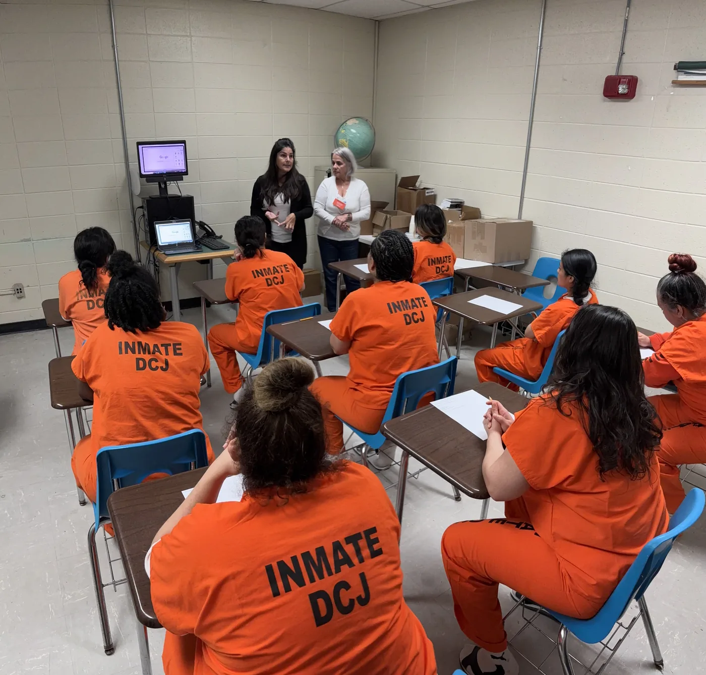 A classroom of students inside TGK jail in Miami listening to two facilitators during a digital skills class.