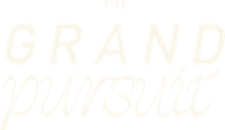 Text reading 'THE GRAND pursuit' with 'GRAND' in uppercase bold letters and 'pursuit' in cursive script.