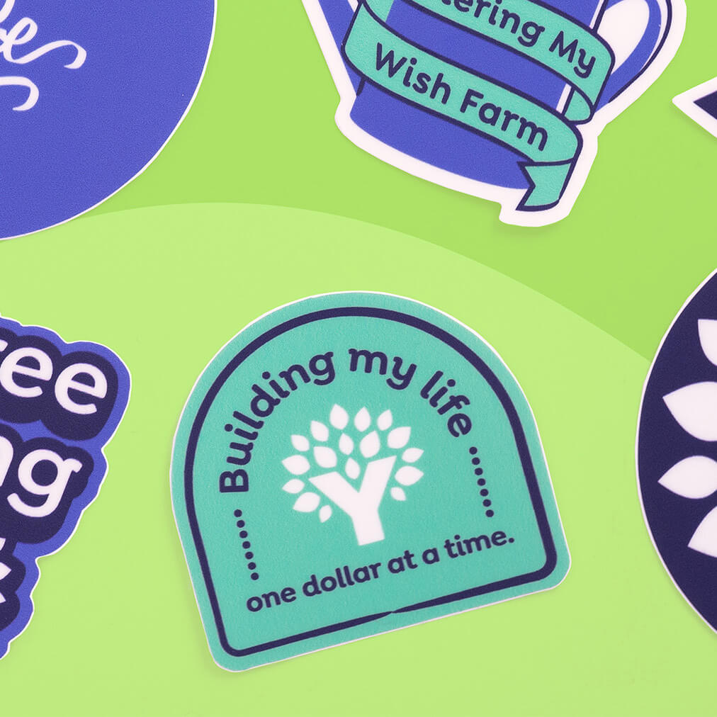 Teal “Building My Life” sticker with white YNAB tree logo on lime green background among other YNAB stickers.